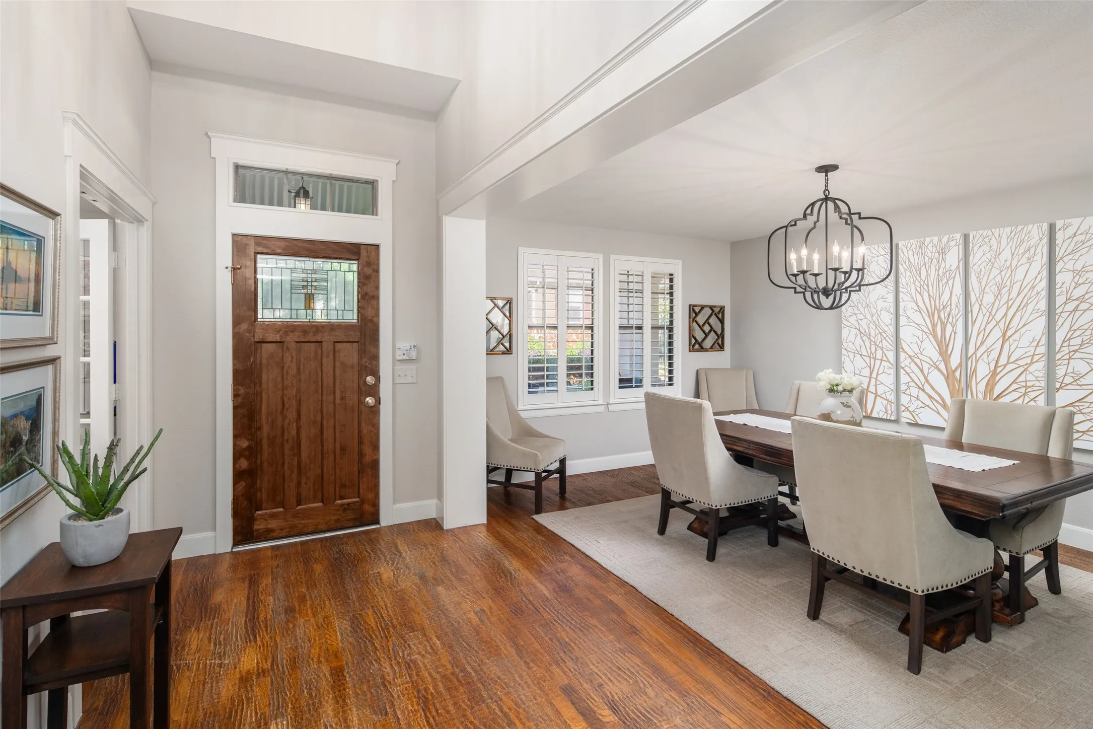 Warm Handscraped Hardwood Floors at Entry with Open Floorplan, and Artisan Craftsman Front door with stained glass detail.