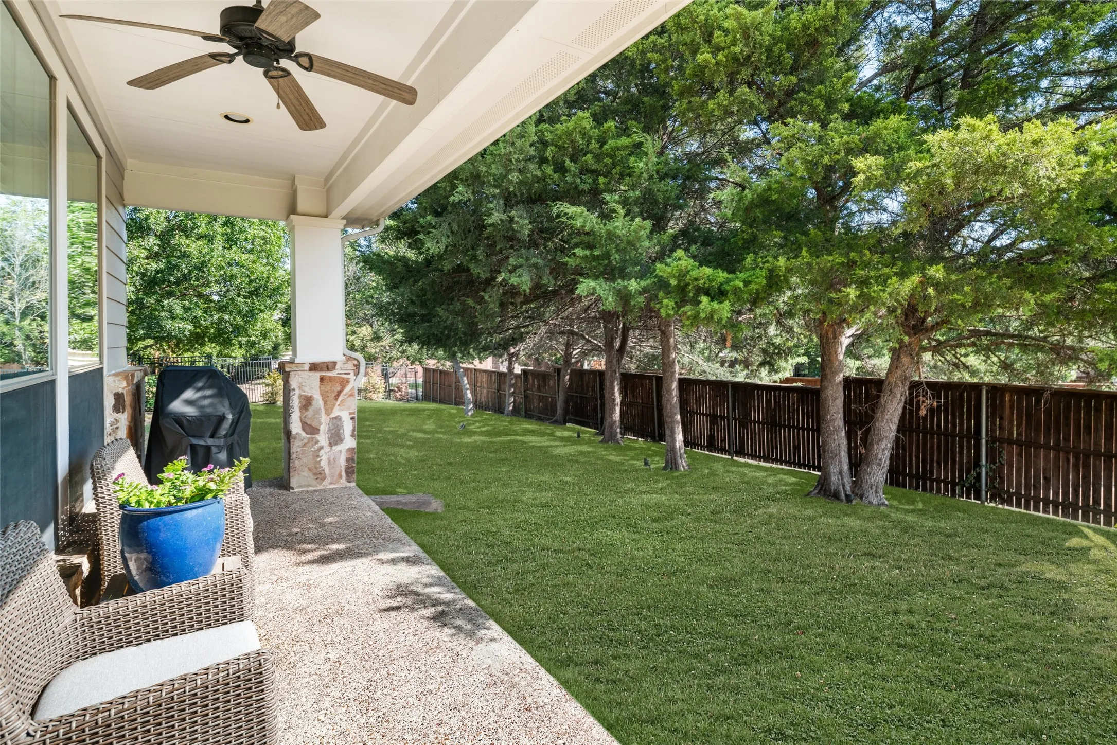 Covered Patio off Living Area with Ceiling fan and serene private backyard views. Some items virtually staged.