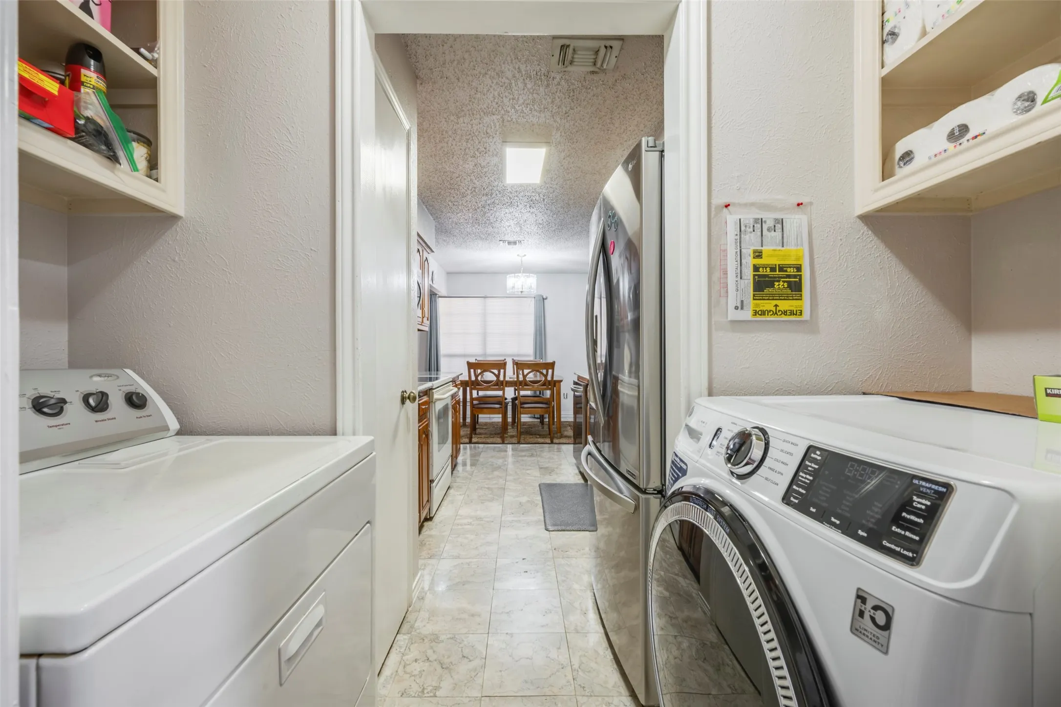 Laundry area with upper cabinetry and durable tile flooring