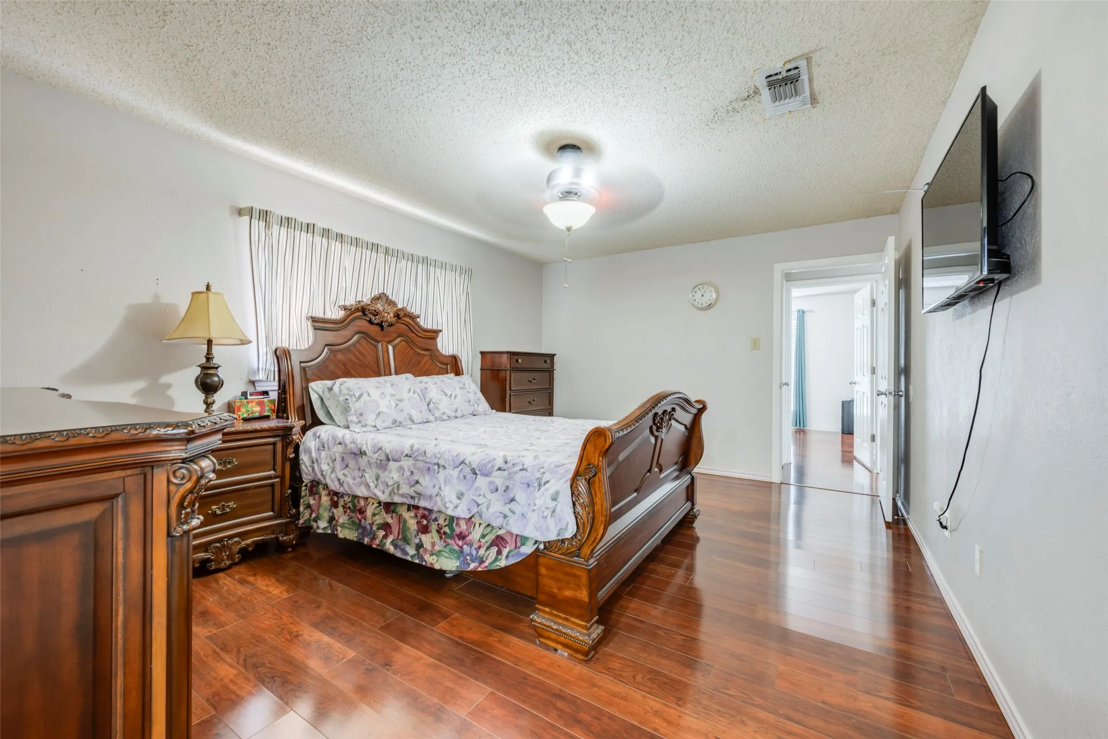 Wood-finish flooring throughout, bright white walls, and a ceiling-mounted light fixture
