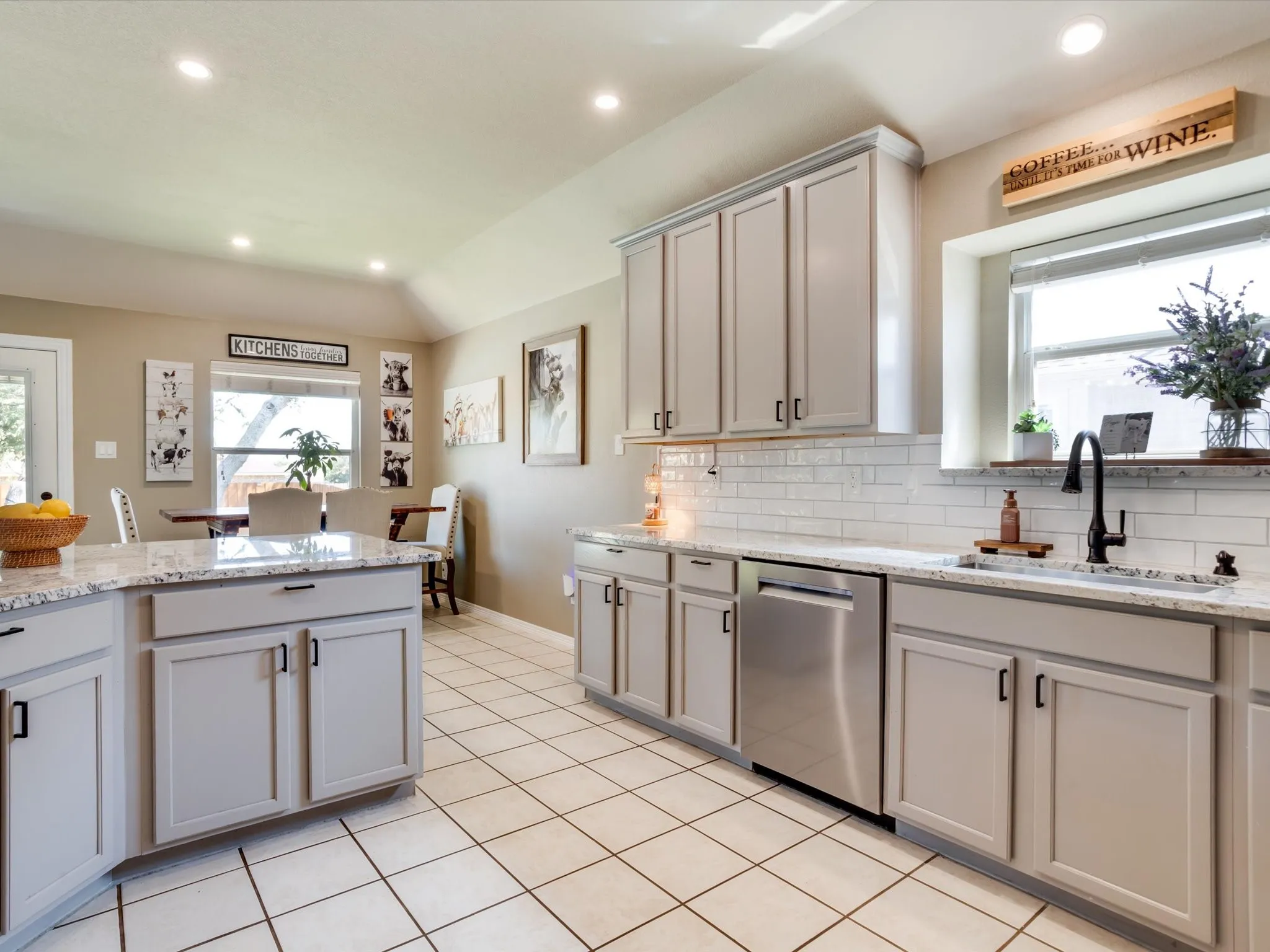 Kitchen featuring light-toned cabinetry, granite-style countertops, subway tile backsplash, stainless steel appliances, and recessed lighting
