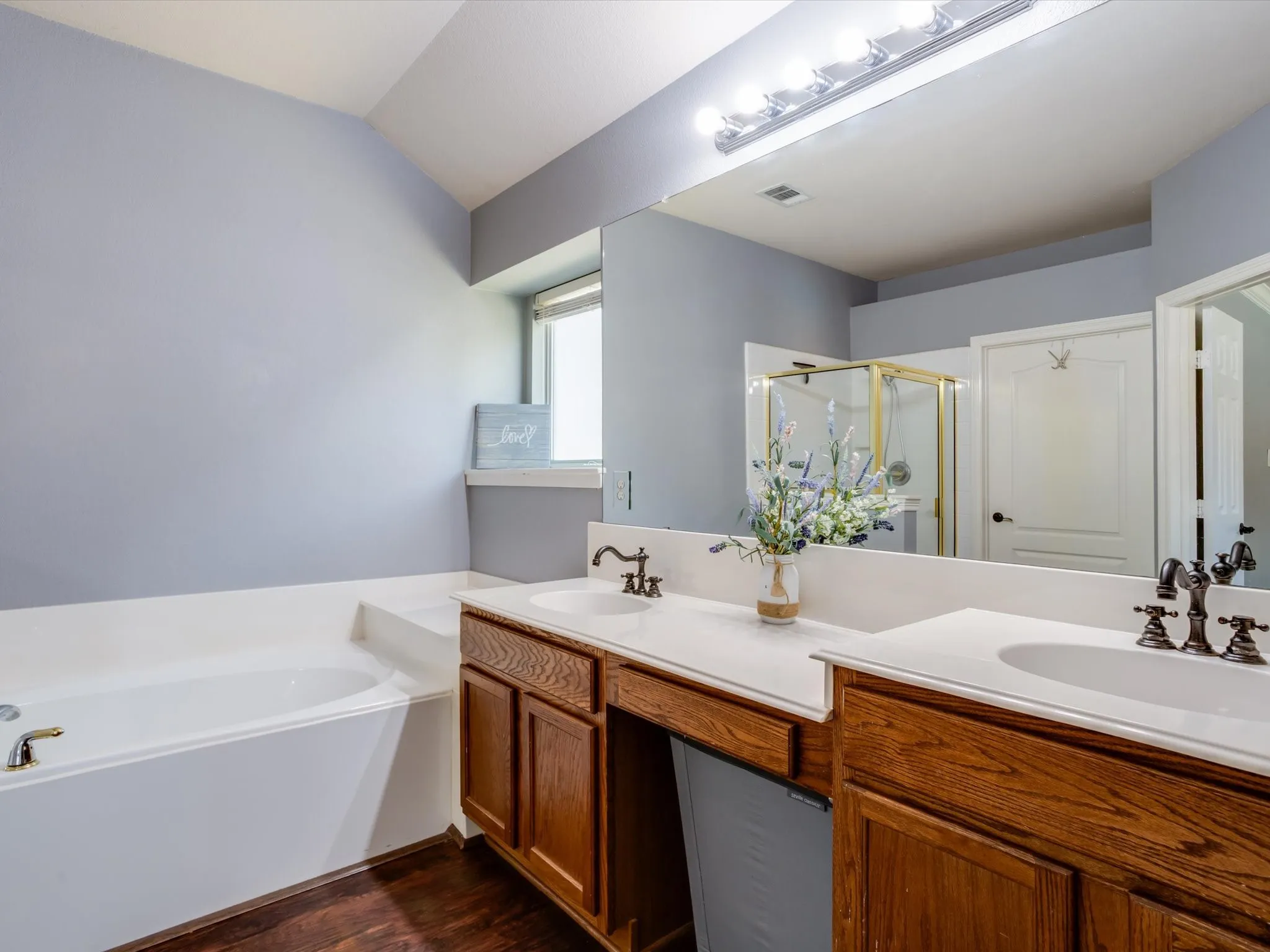 Dual vanity with integrated sinks and wood-finish cabinetry