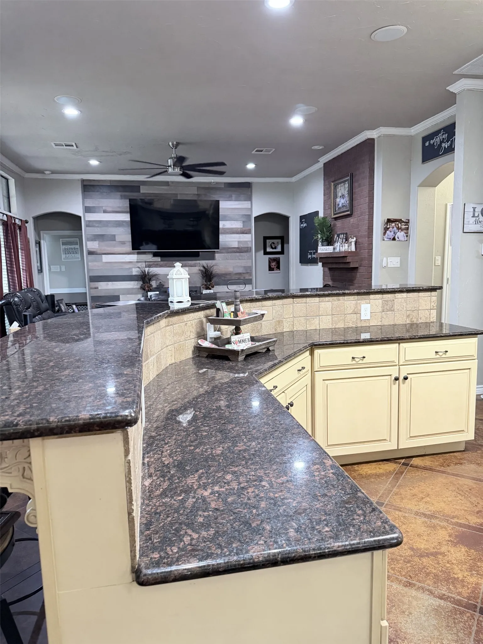 Kitchen featuring dark stone countertops, cream-painted cabinetry, and a tile backsplash