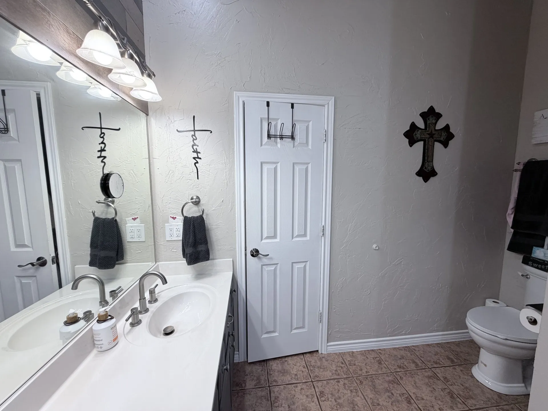 Dual basin vanity with a light-toned countertop, brushed nickel fixtures, and a wall-mounted light bar