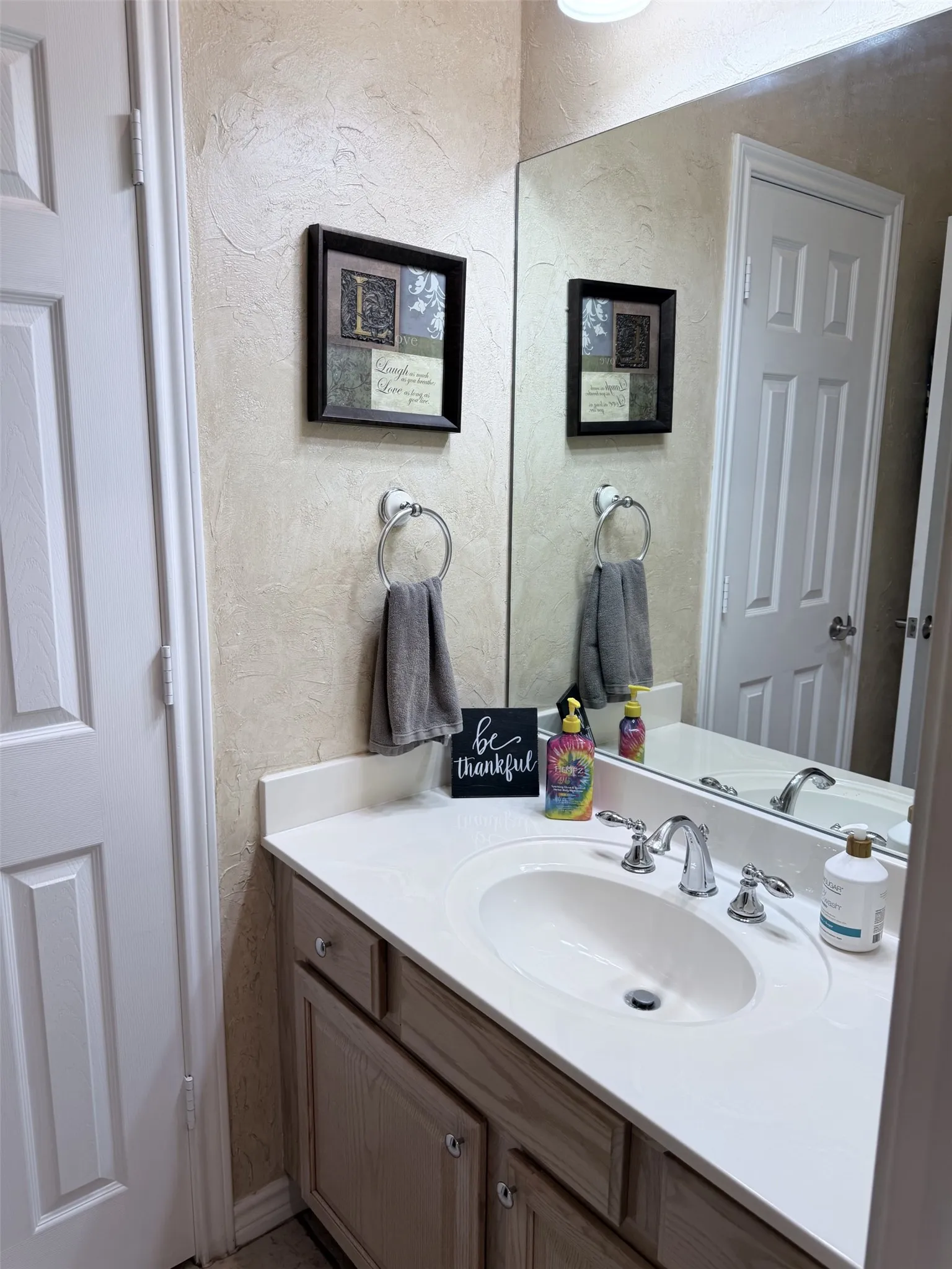 Vanity with a built-in sink, chrome fixtures, and light-toned cabinetry