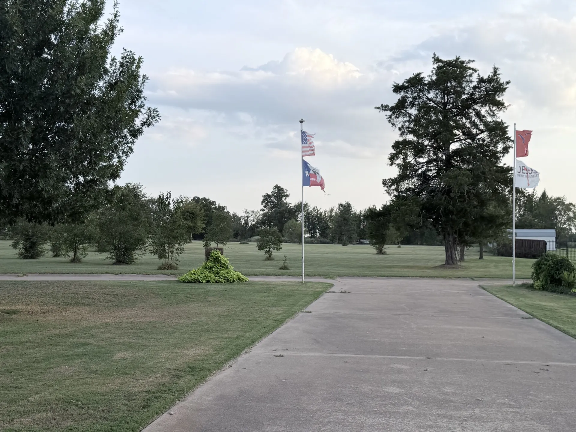 Expansive lawn with mature trees and concrete pathways