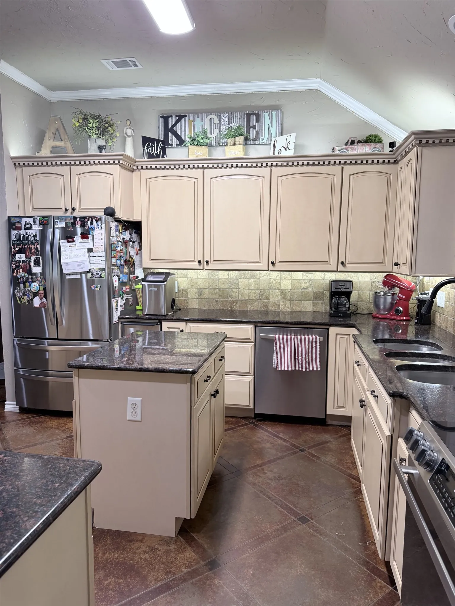 Kitchen featuring an island, recessed lighting, stainless steel appliances, and dark countertops