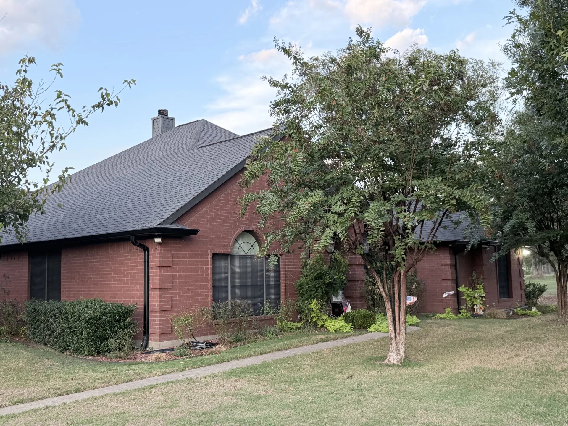 Red brick exterior with a gray shingle roof