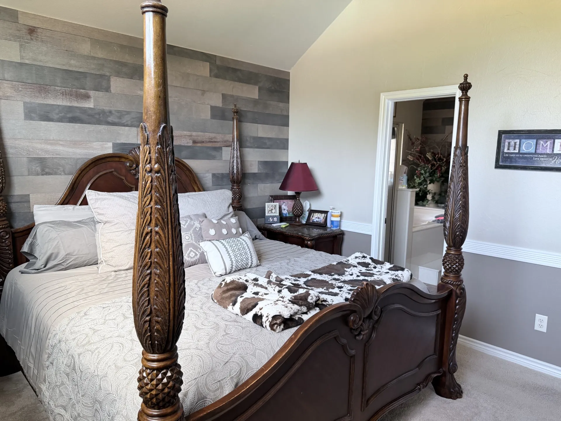Vaulted ceiling with an accent wall, painted two-tone walls, and a doorway to an adjoining space