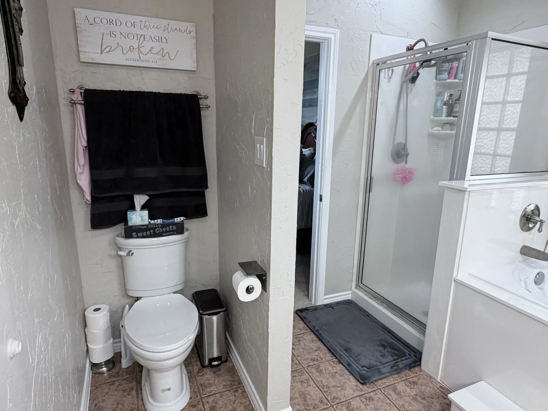 Walk-in shower with clear glass enclosure and tile flooring