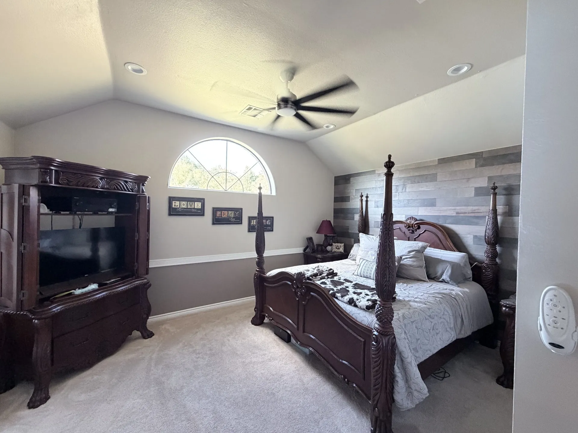 Vaulted ceiling featuring recessed lighting, ceiling fan, and arched window