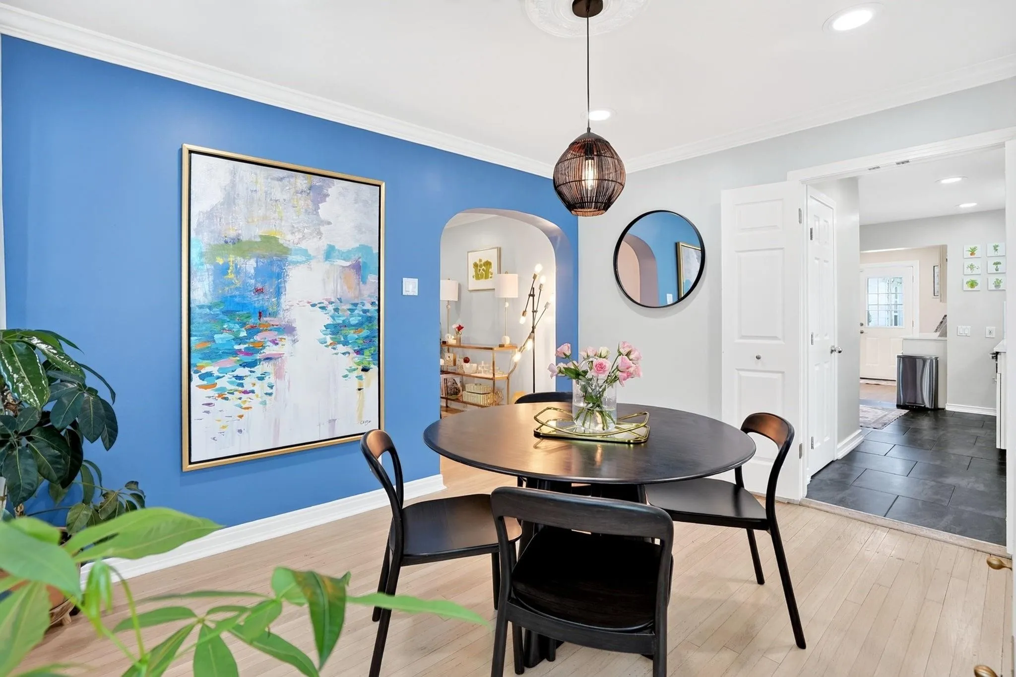 Hardwood-finish flooring, recessed lighting, and a decorative ceiling medallion complement the arched entryway