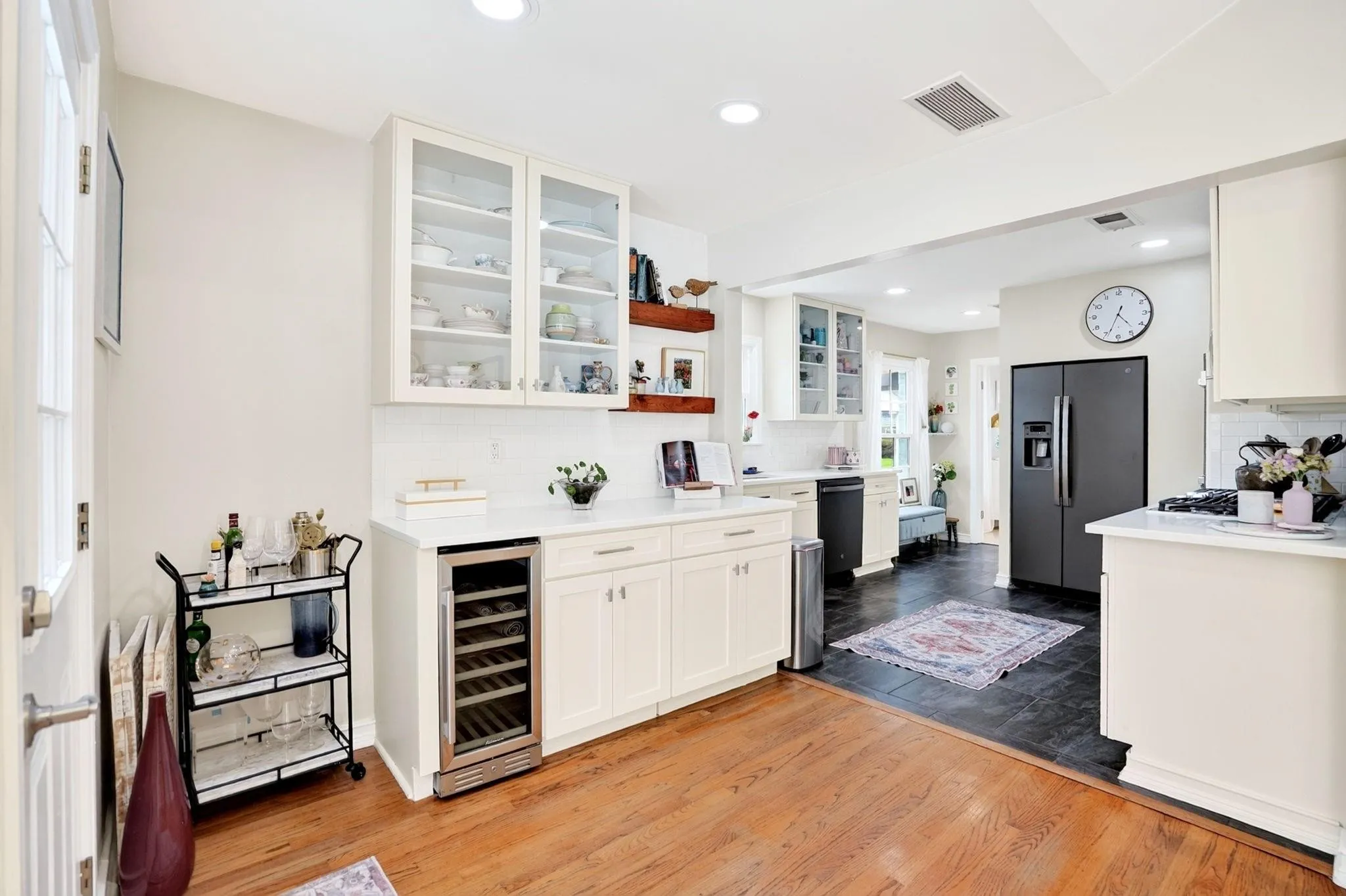 Hardwood flooring, recessed lighting, white cabinetry, glass-front upper cabinets, and a built-in beverage cooler