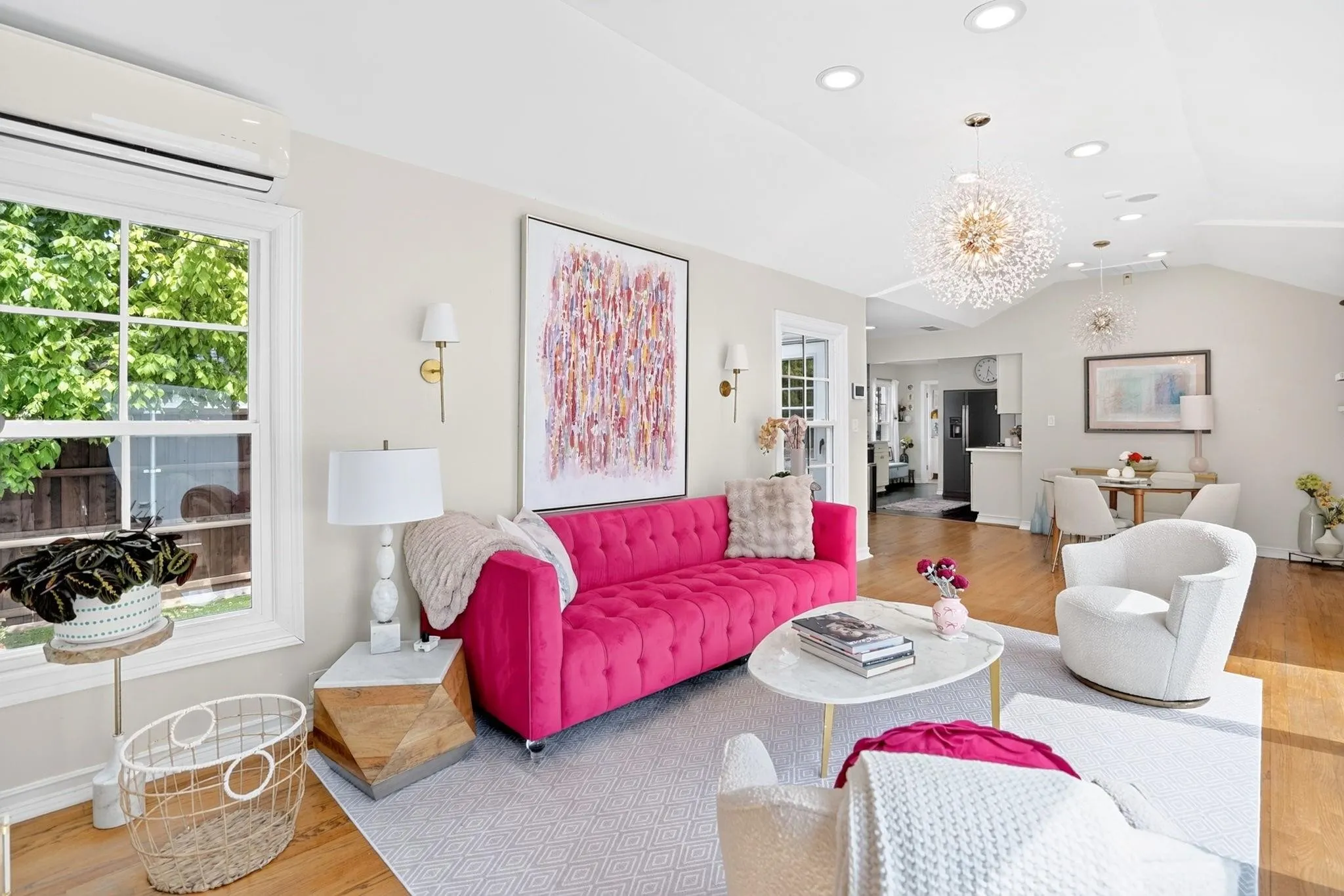 Vaulted ceiling with recessed lighting, wood-finish flooring, wall-mounted sconces, and a split air conditioning unit