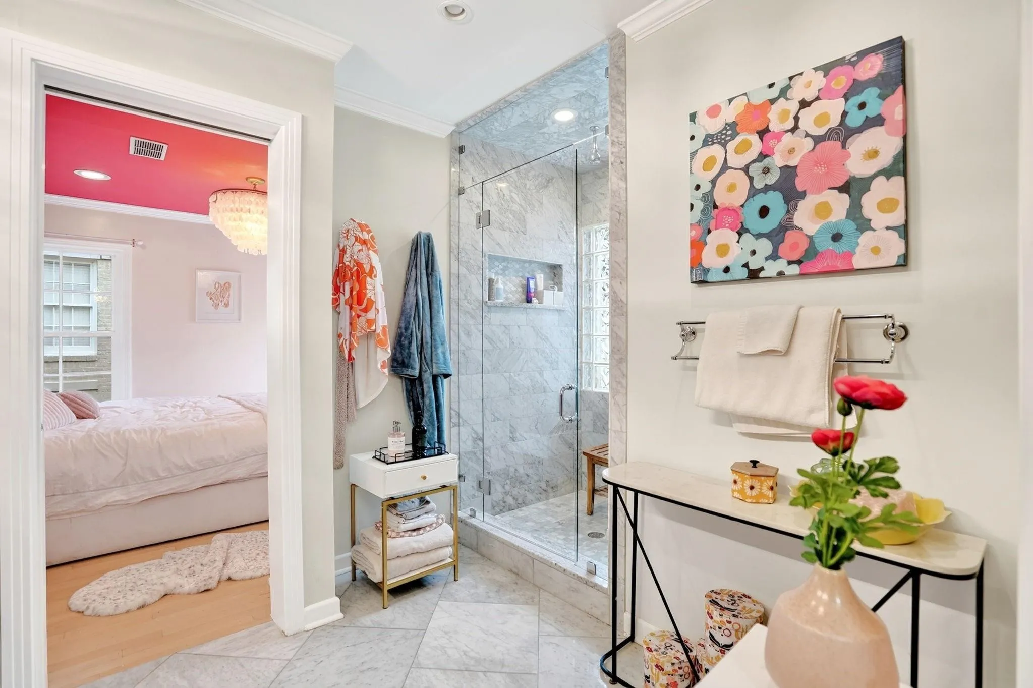 Tiled flooring extending to a glass-enclosed shower with tiled walls and a recessed niche
