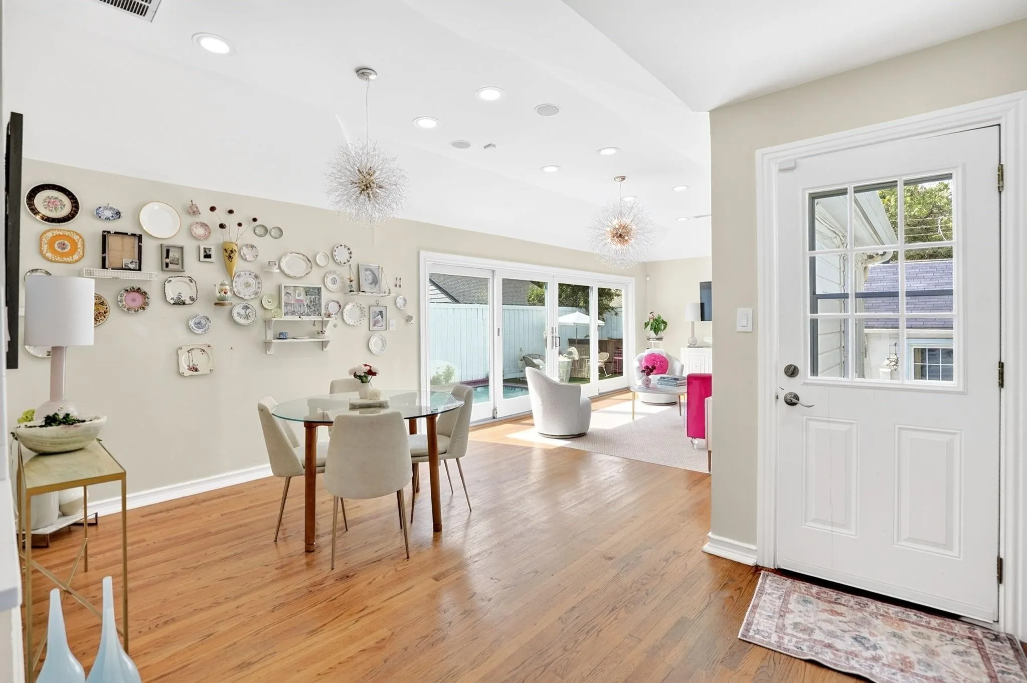 Hardwood flooring, recessed lighting, and a white paneled door with window inserts