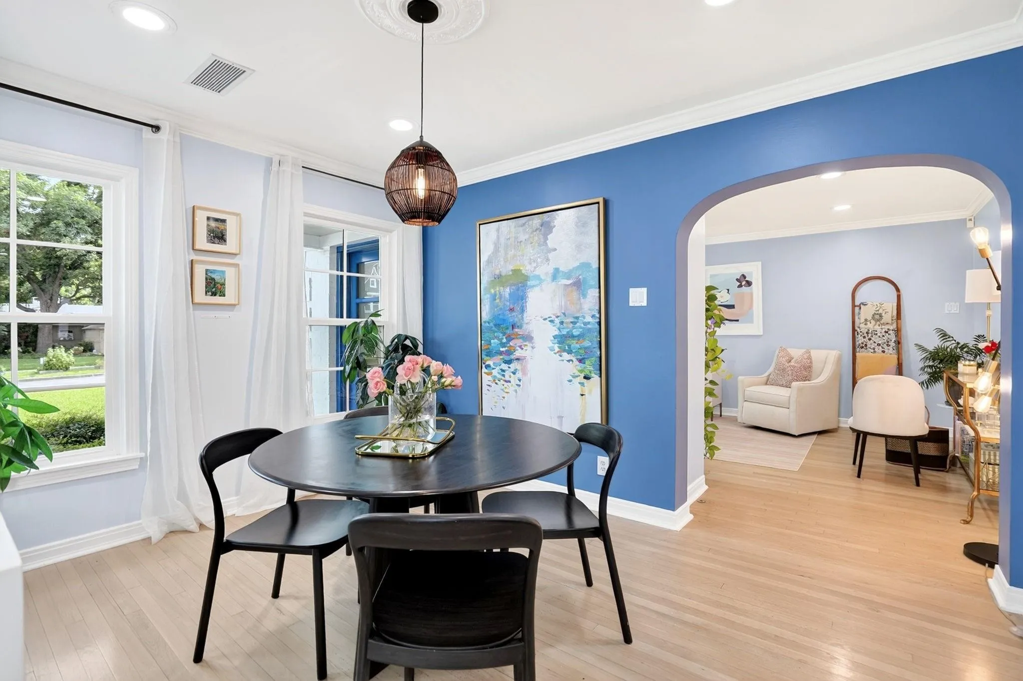 Hardwood-style flooring throughout, arched doorway, recessed lighting, and a decorative ceiling medallion