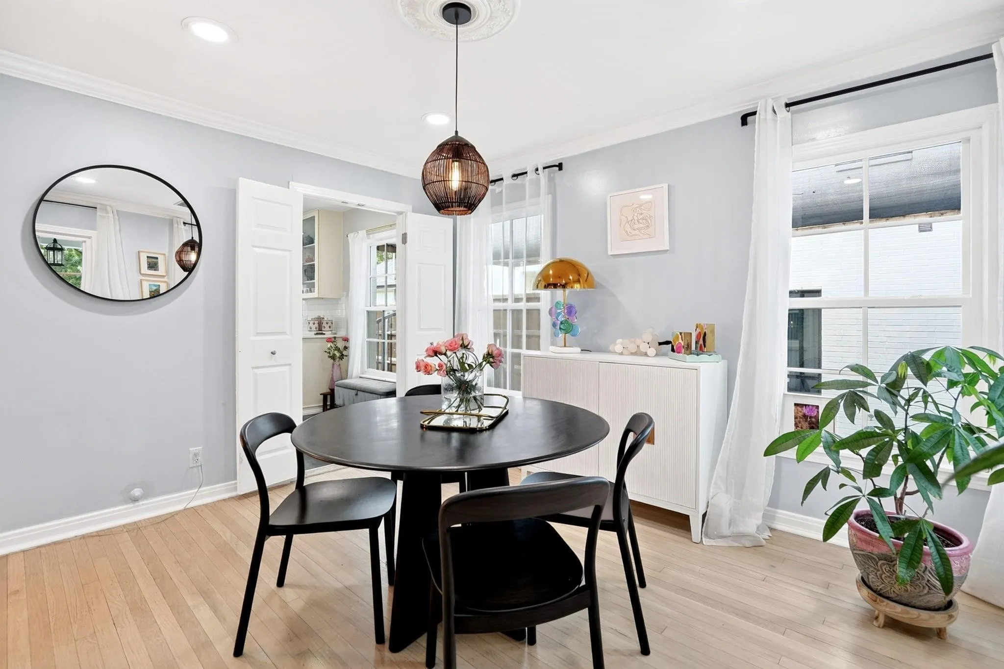 Light wood-finish flooring with white baseboards and crown molding