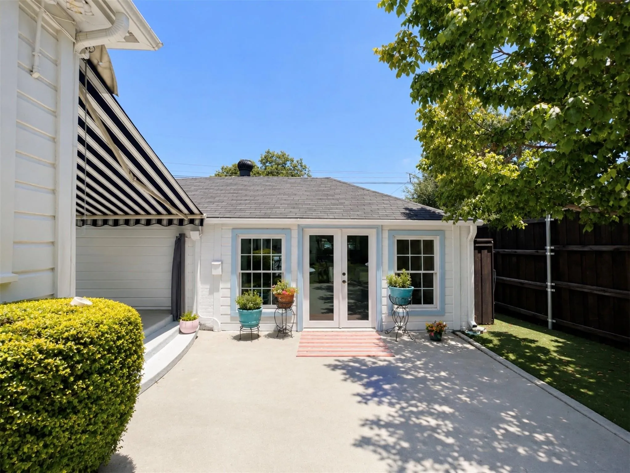 Detached structure with French doors, multiple windows, and a shingled roof