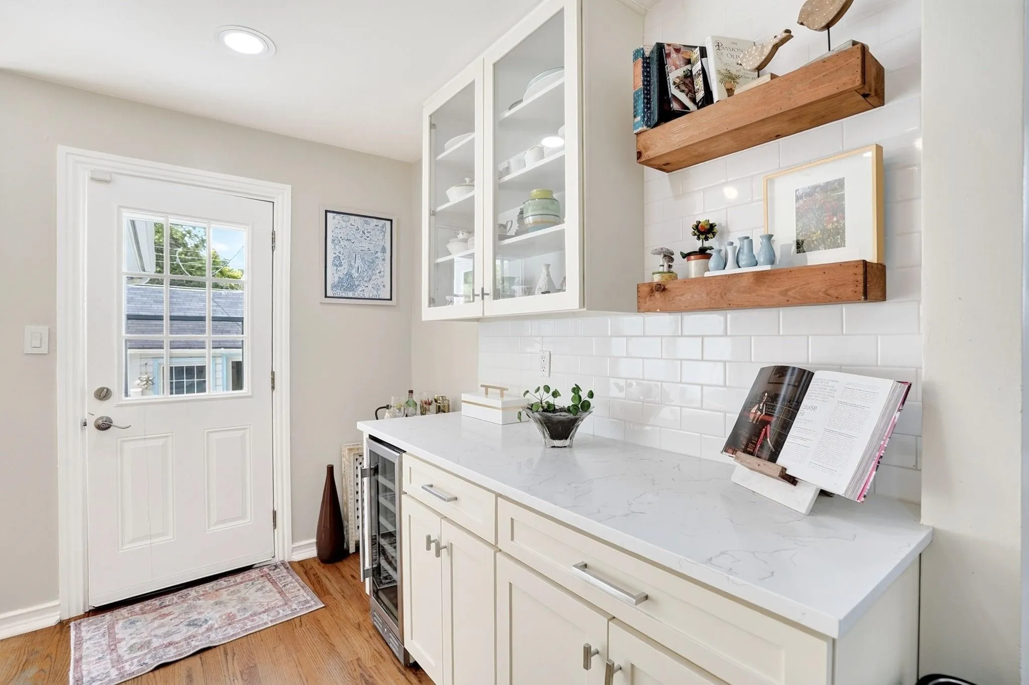 White shaker cabinetry, light-toned countertops, white subway tile backsplash, and recessed lighting