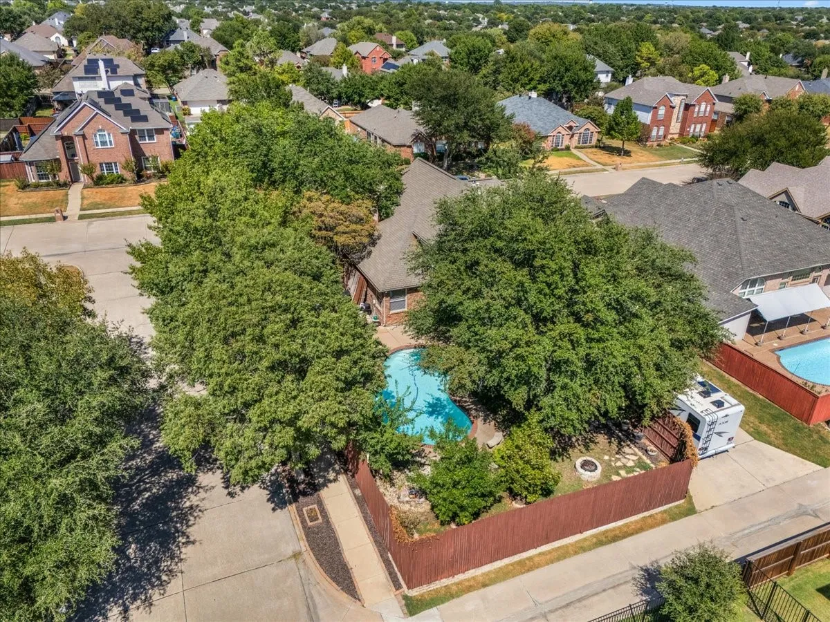 Private backyard with mature trees, fenced perimeter, and a swimming pool