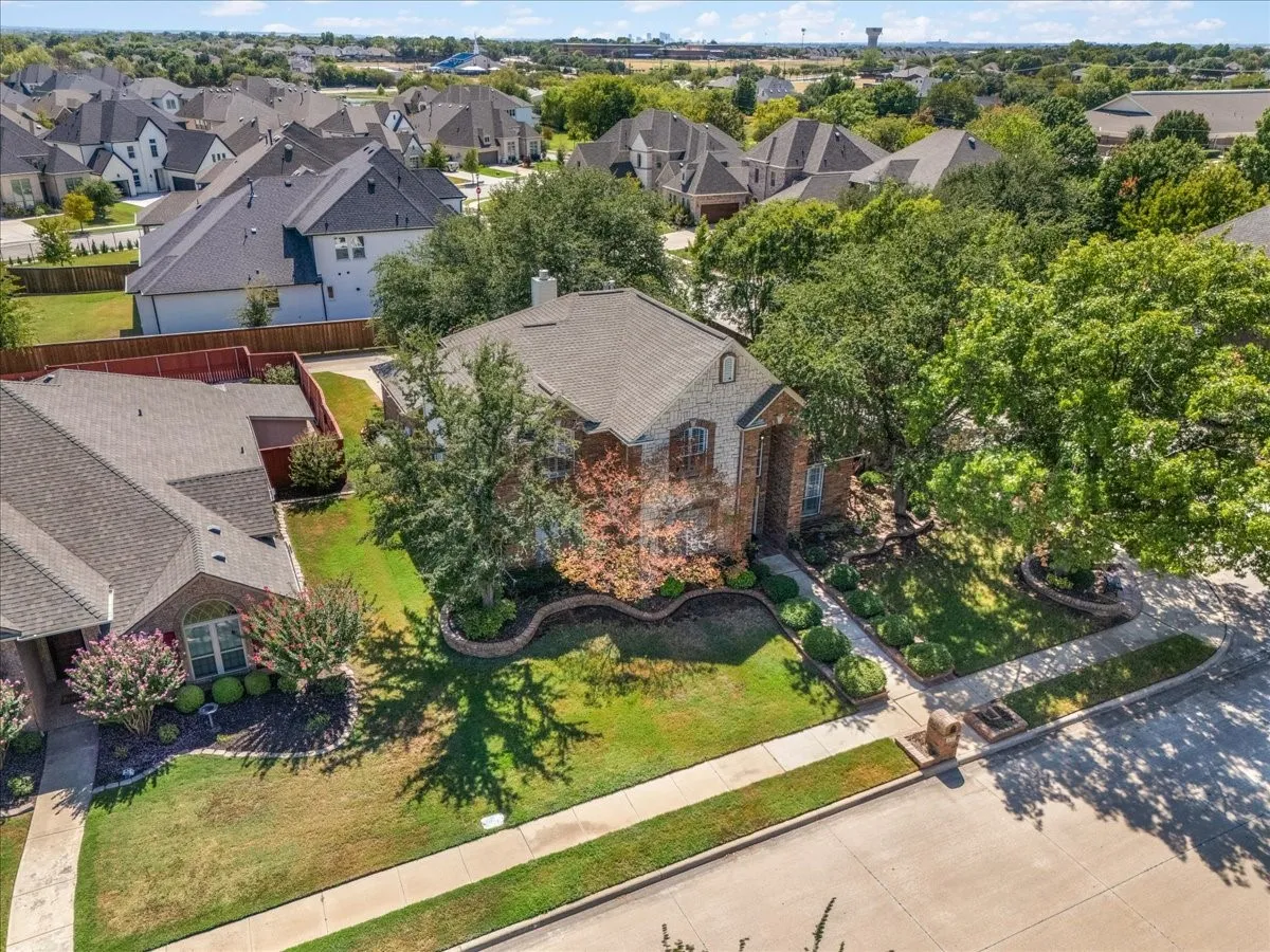 Brick exterior, gabled roofline, established trees, landscaped front yard, and concrete sidewalks