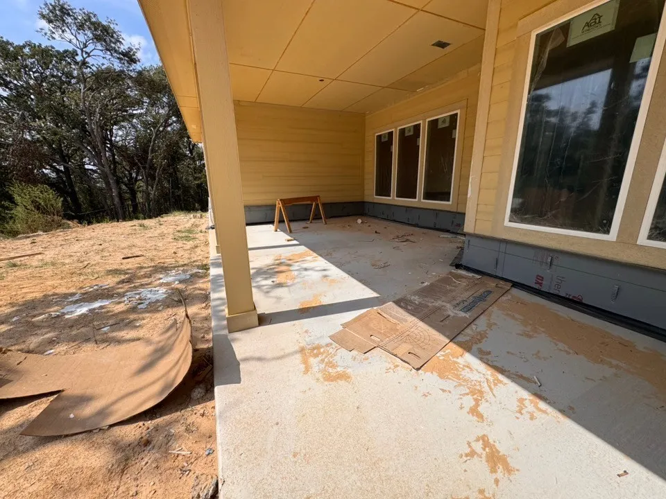 Covered concrete patio with horizontal siding and multiple large windows