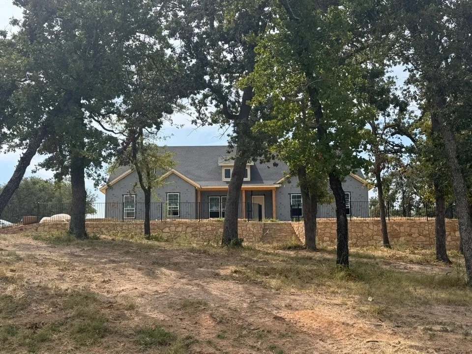 Siding exterior with dormer window, covered entry, and black iron fencing