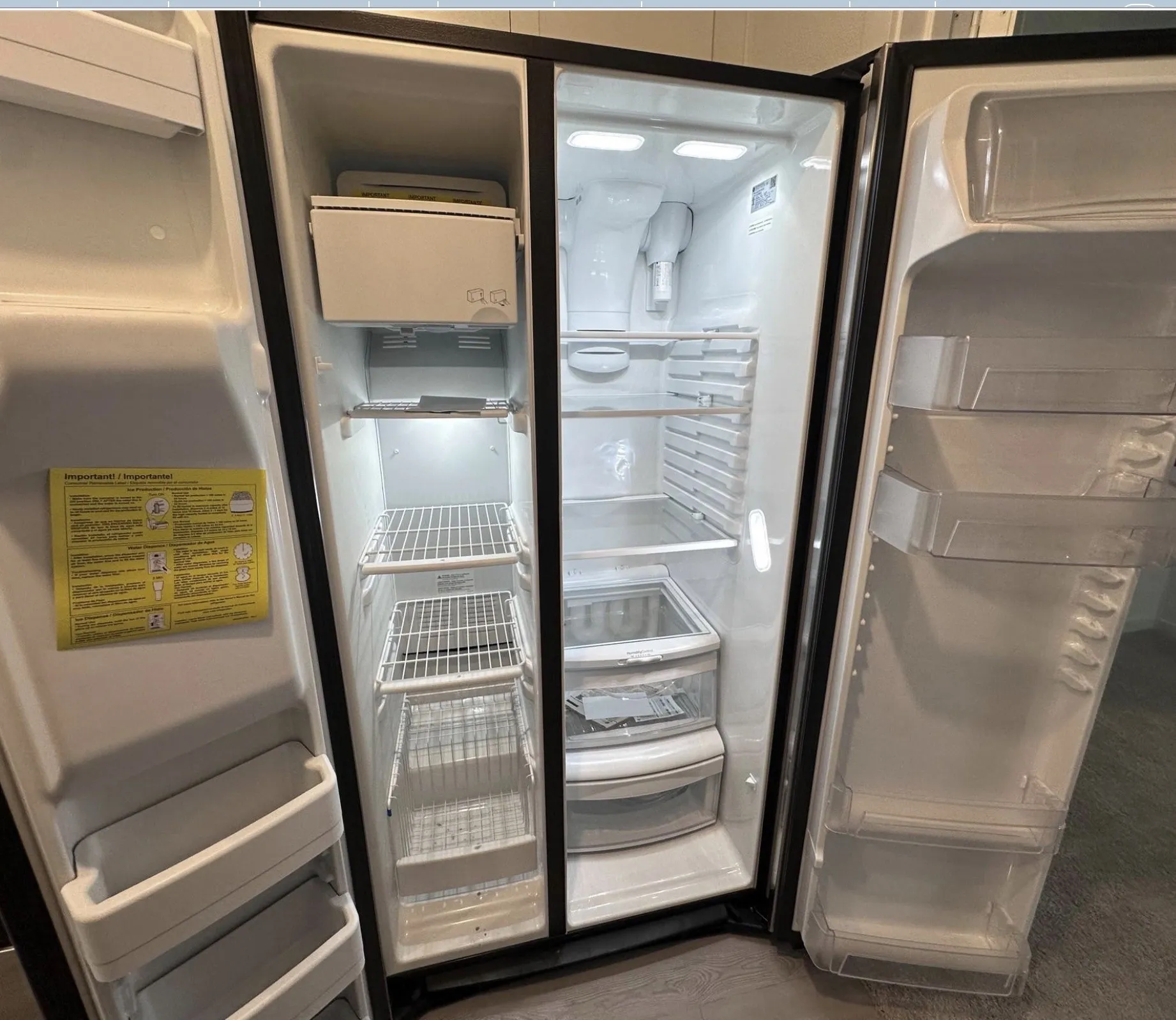 Side-by-side refrigerator featuring wire shelving, integrated ice maker, and clear door storage bins
