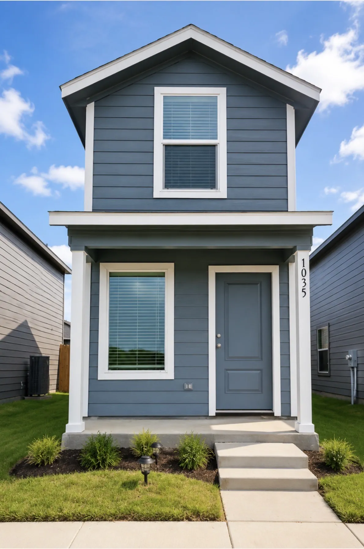 Modern two-story home featuring gray-blue siding and white trim