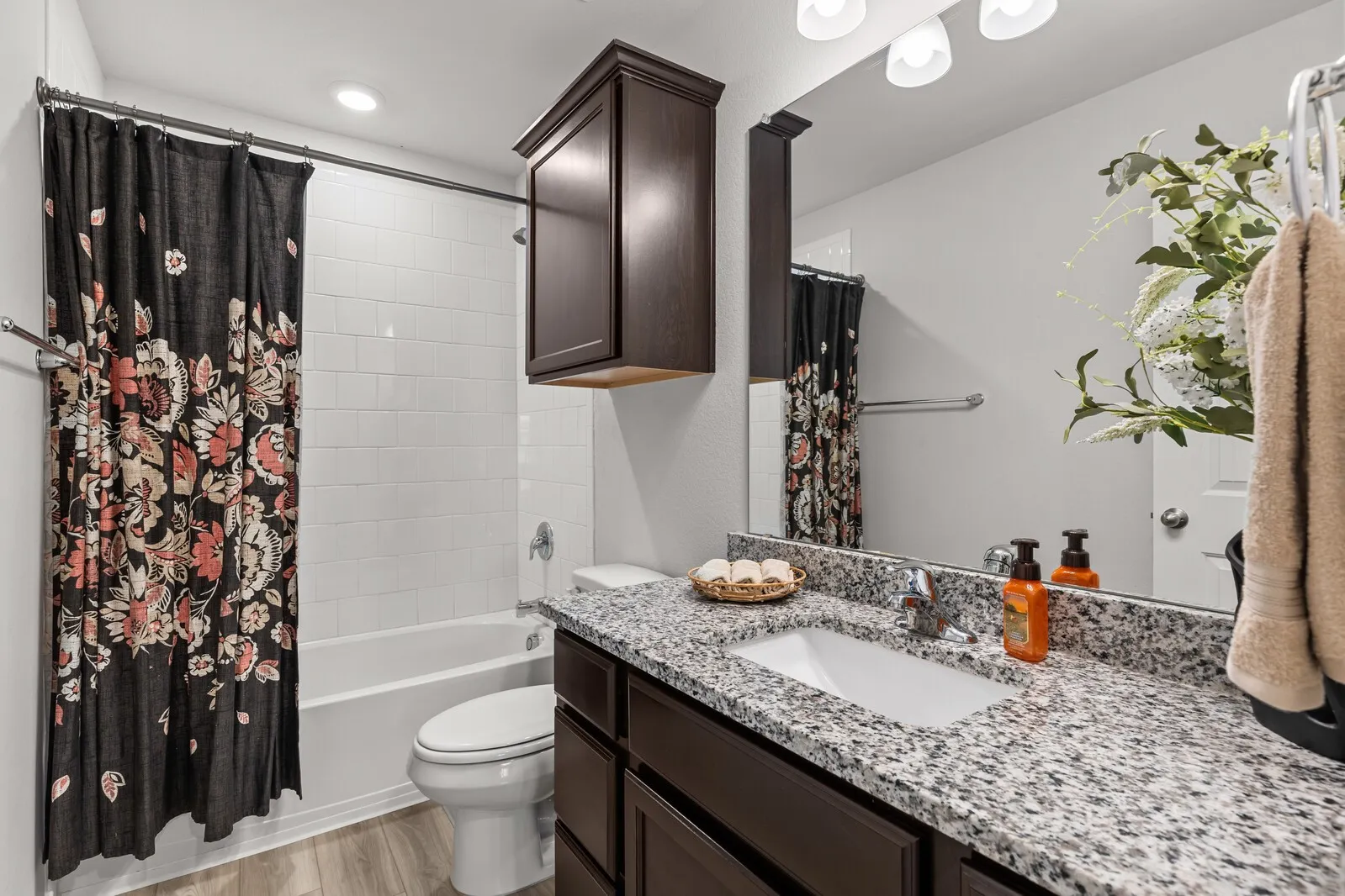 Bathroom featuring a vanity with a granite countertop, undermount sink, and wood-finish cabinetry