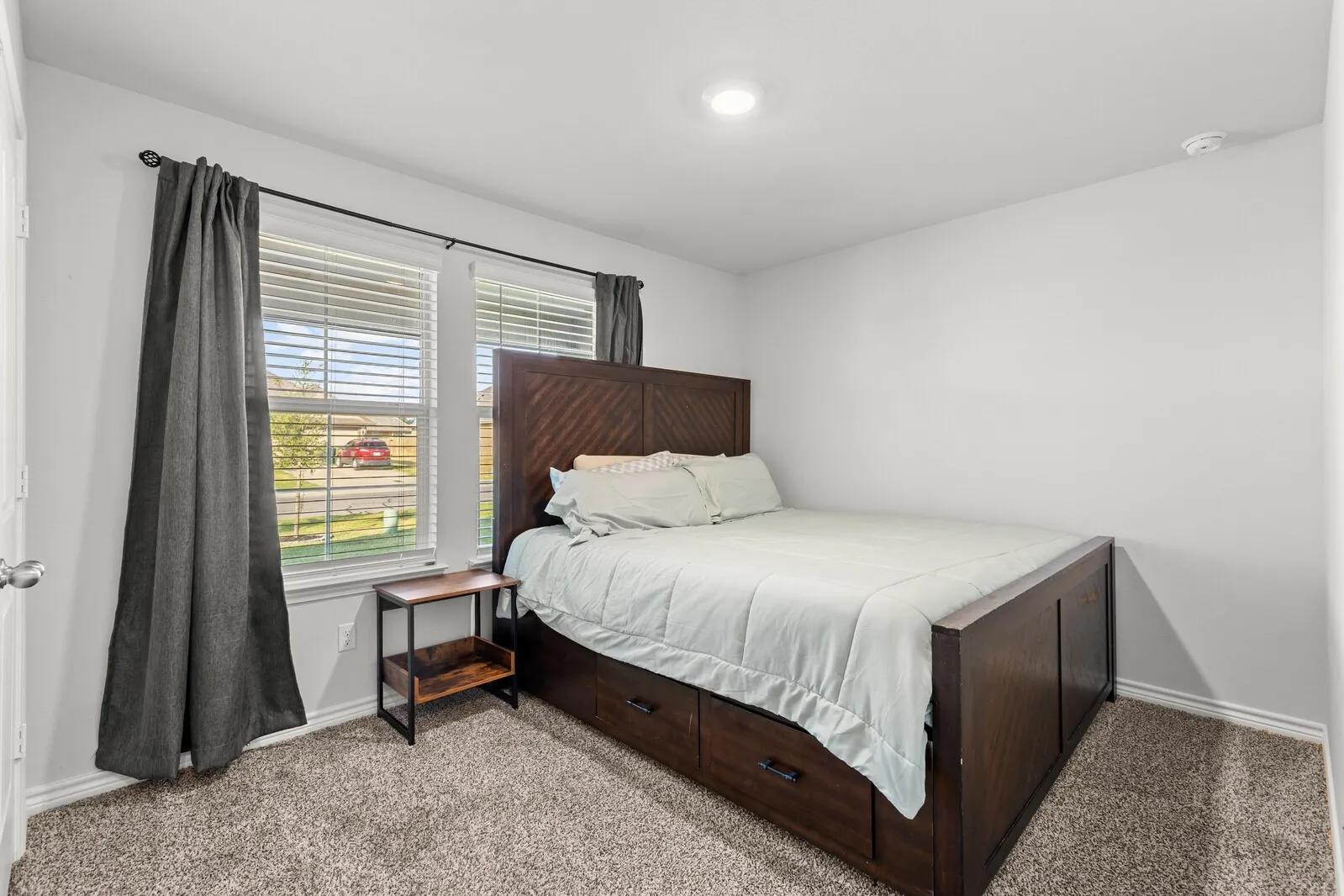 Carpeted room featuring multiple windows with blinds, recessed lighting, and white walls (actual room 1)