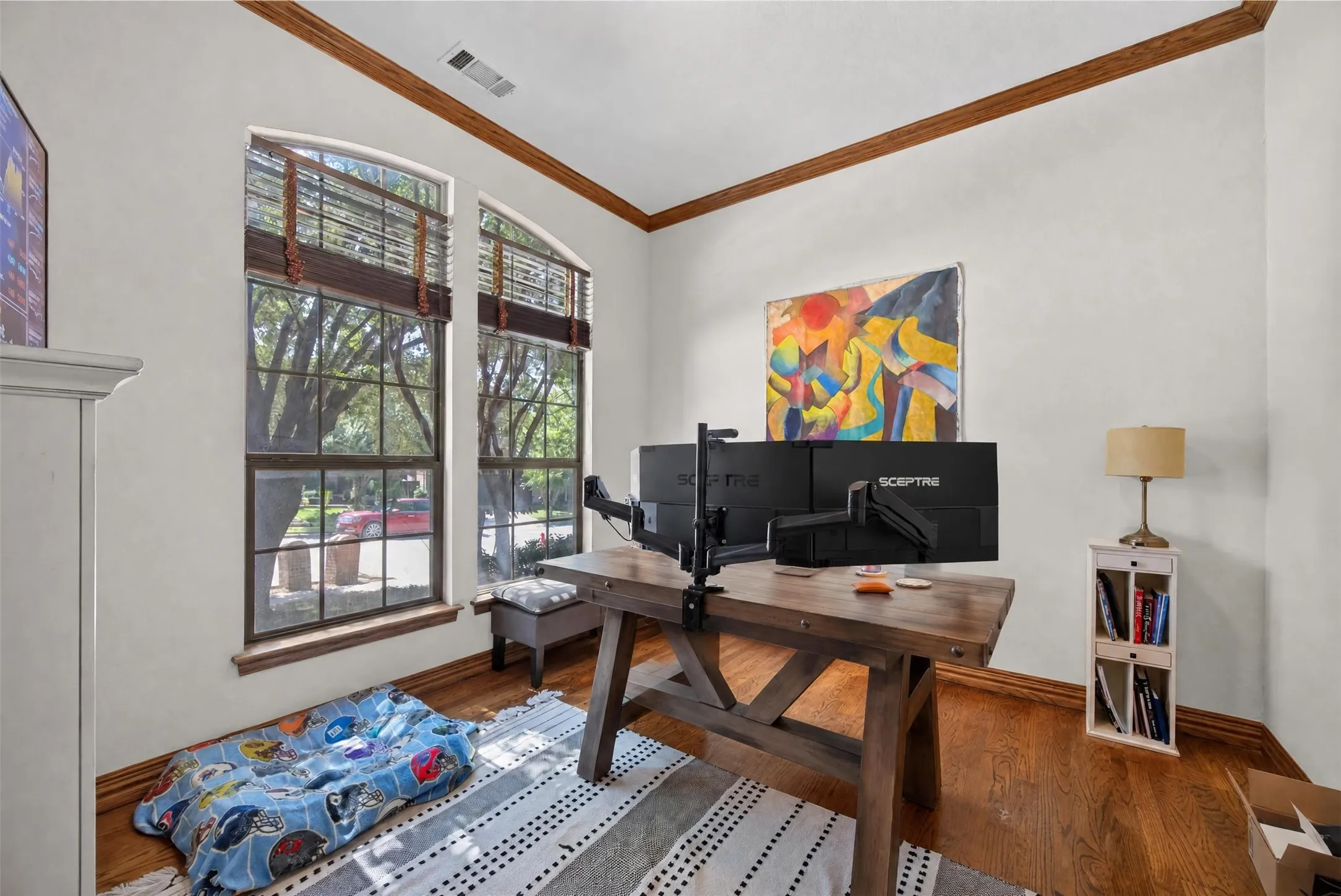 Hardwood flooring throughout, arched window frames, and wood trim