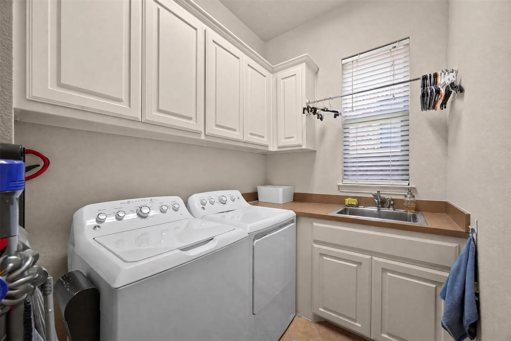 Upper and lower cabinetry with integrated sink, countertop, and window