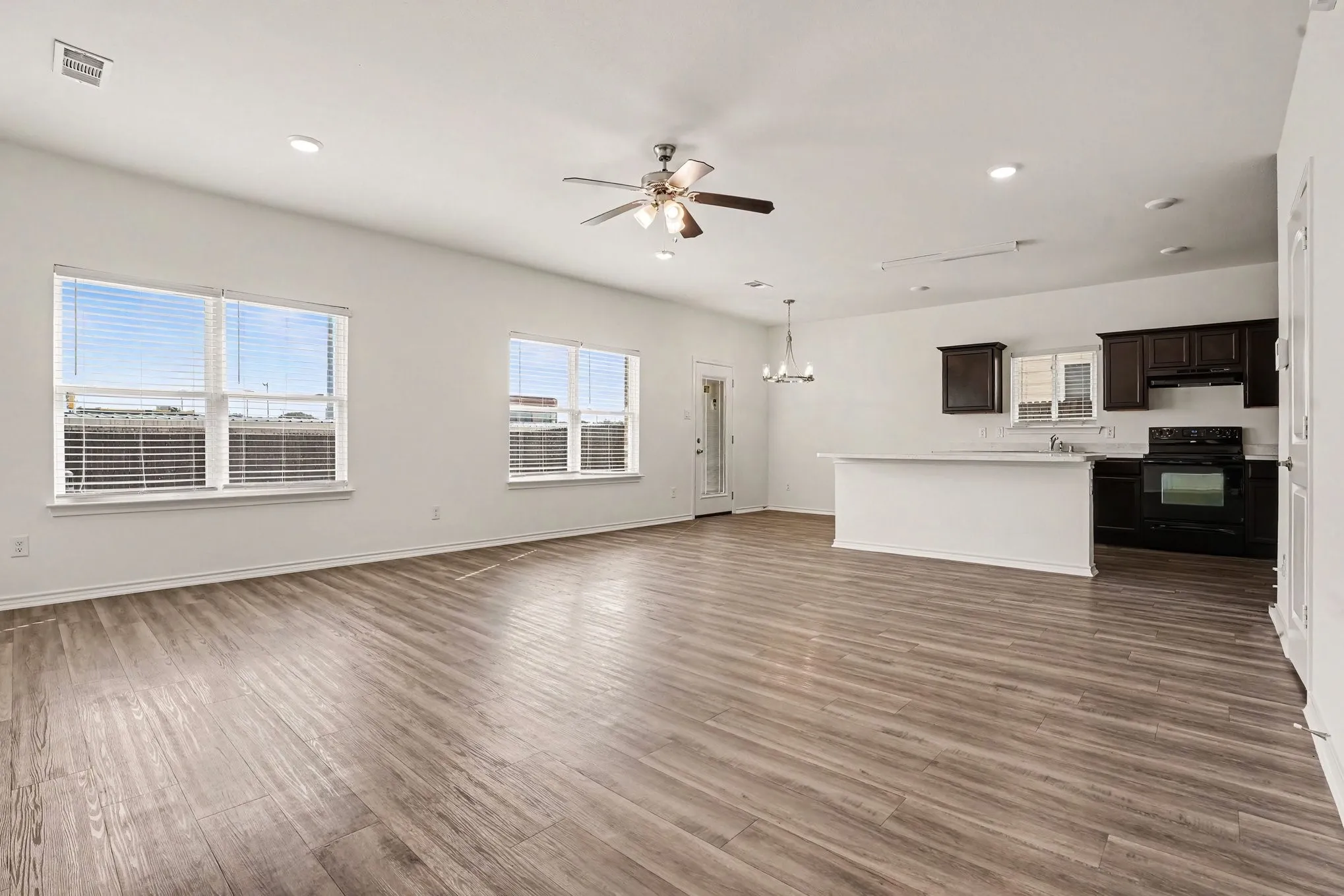 Windows bring natural light into the open living area, with the kitchen close by.