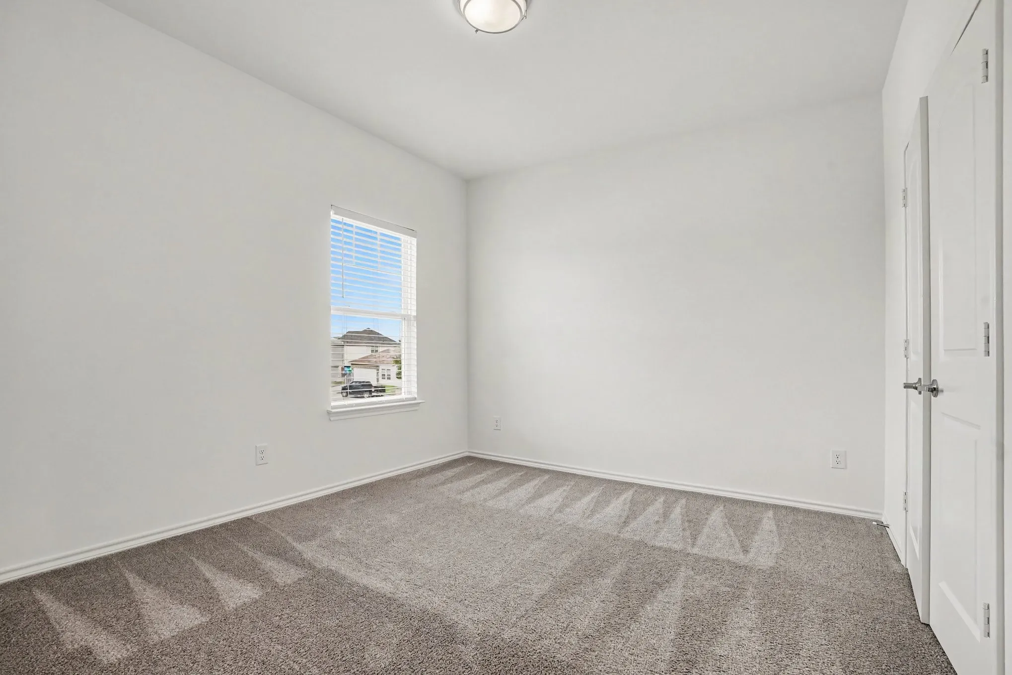 A secondary bedroom with neutral finishes and natural light.