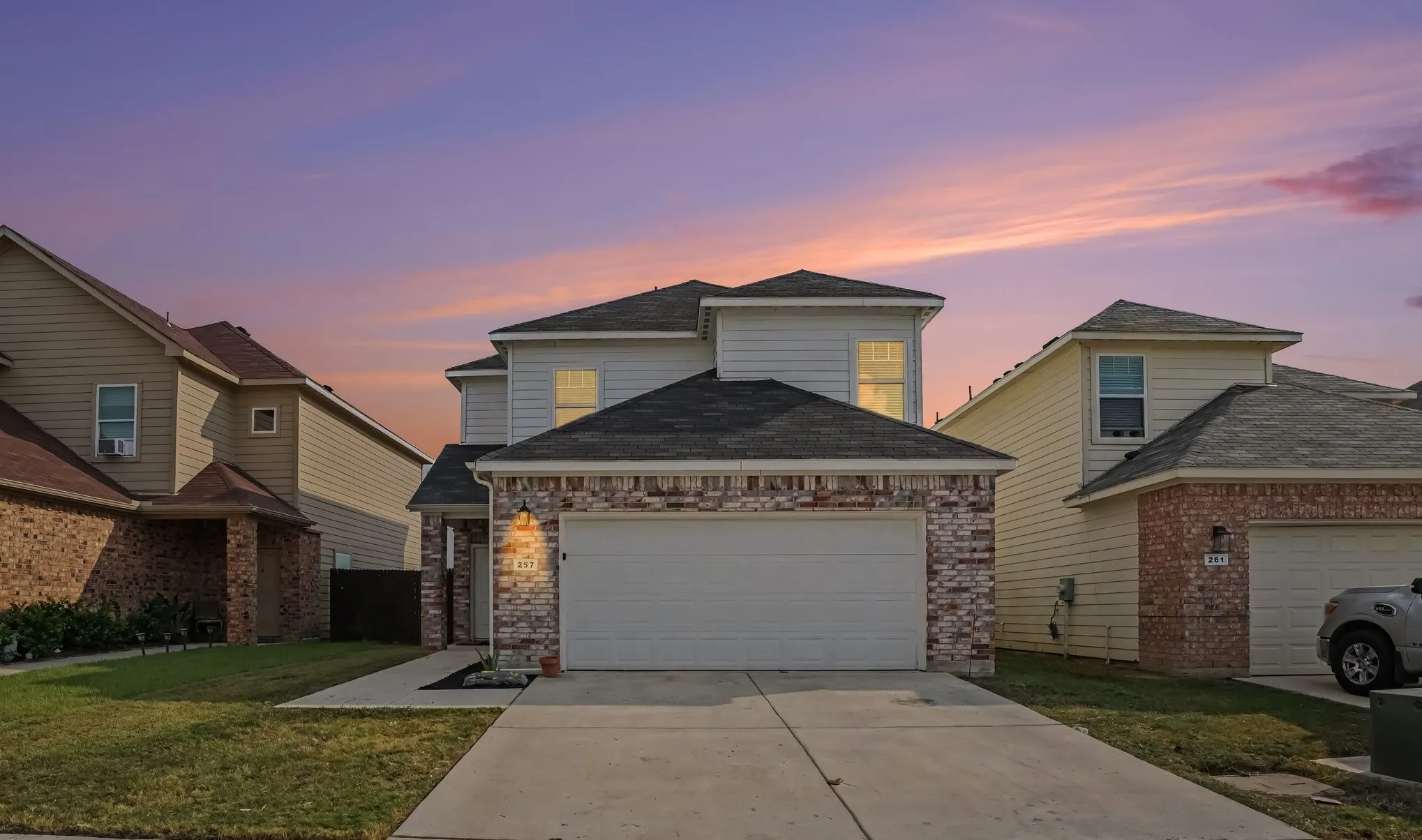 Twilight view of the home with a two-car garage and a welcoming front approach.