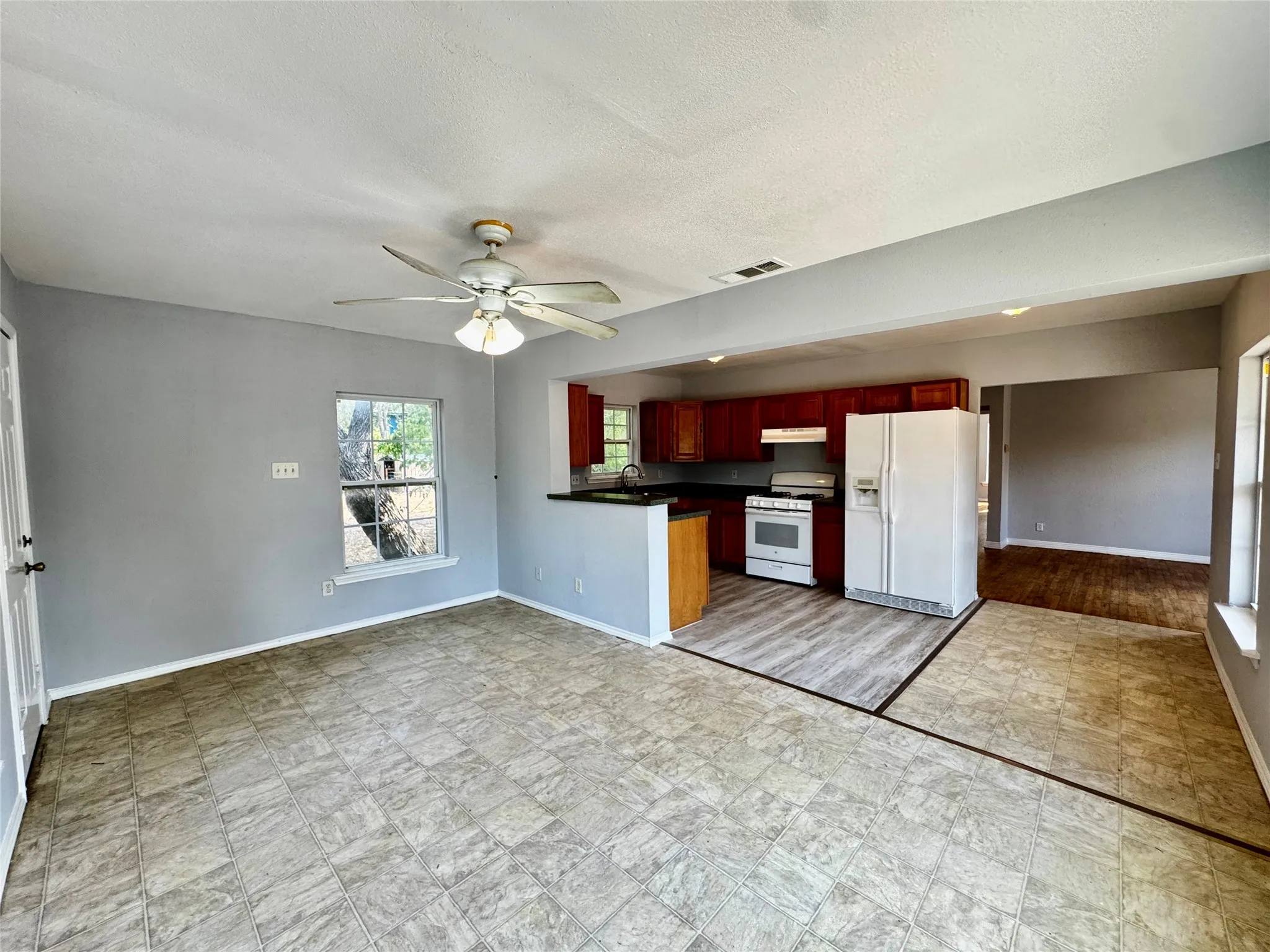 Kitchen featuring cherry-finish cabinetry, a white gas range, and a white refrigerator