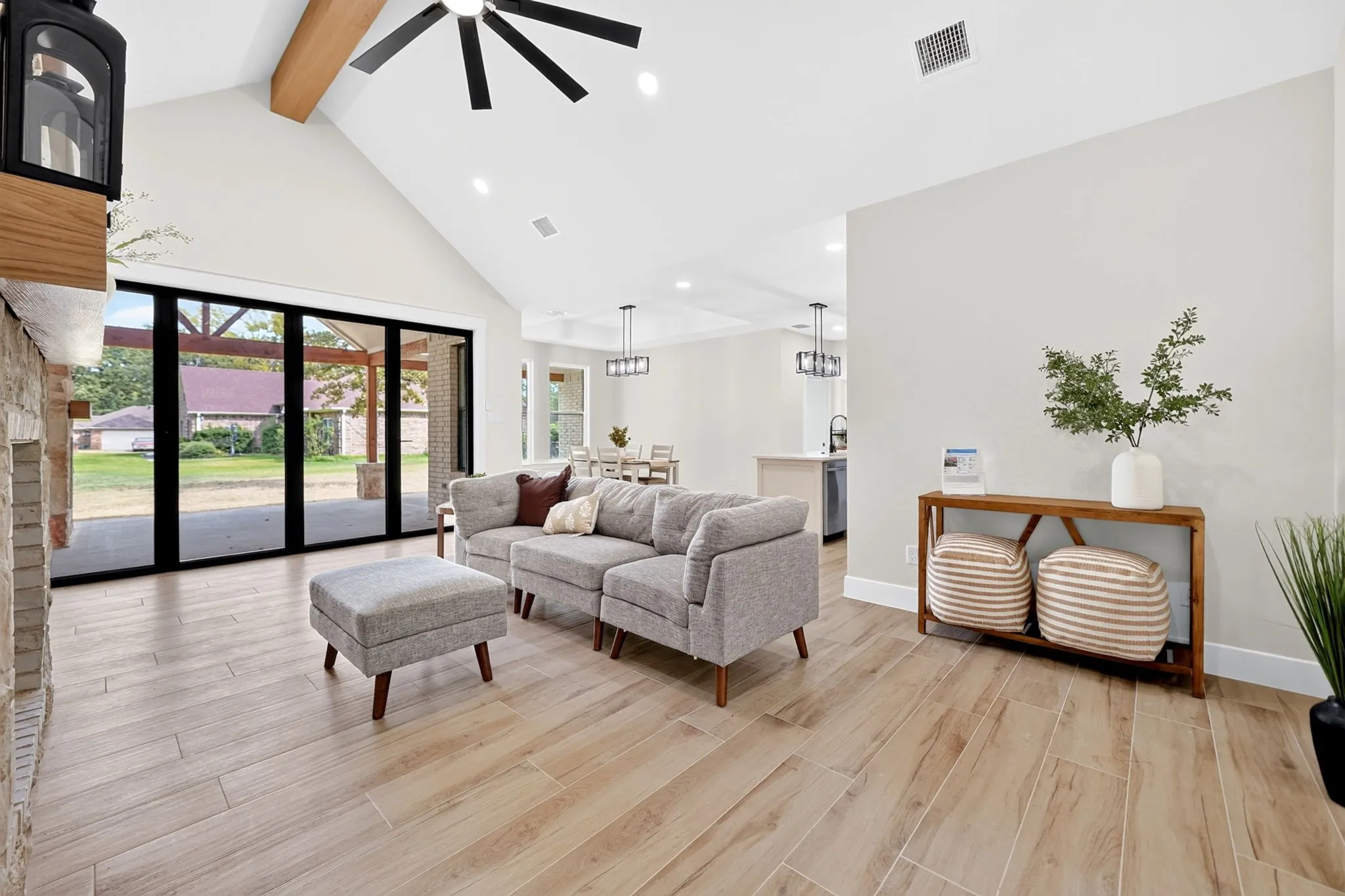 Vaulted ceiling with exposed wood beam, recessed lighting, and a ceiling fan