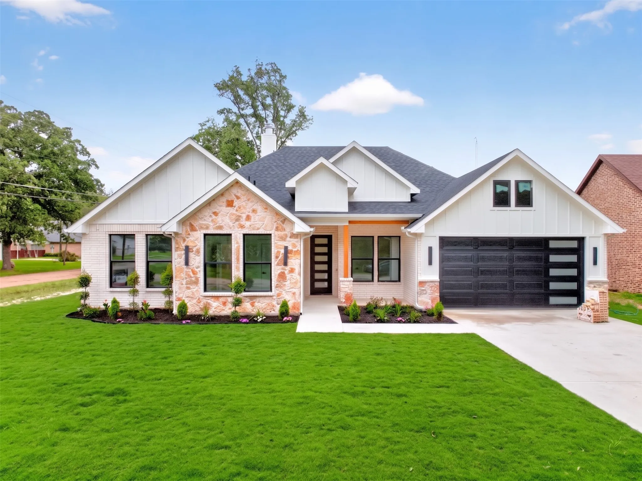 Modern farmhouse exterior featuring white brick and natural stone accents