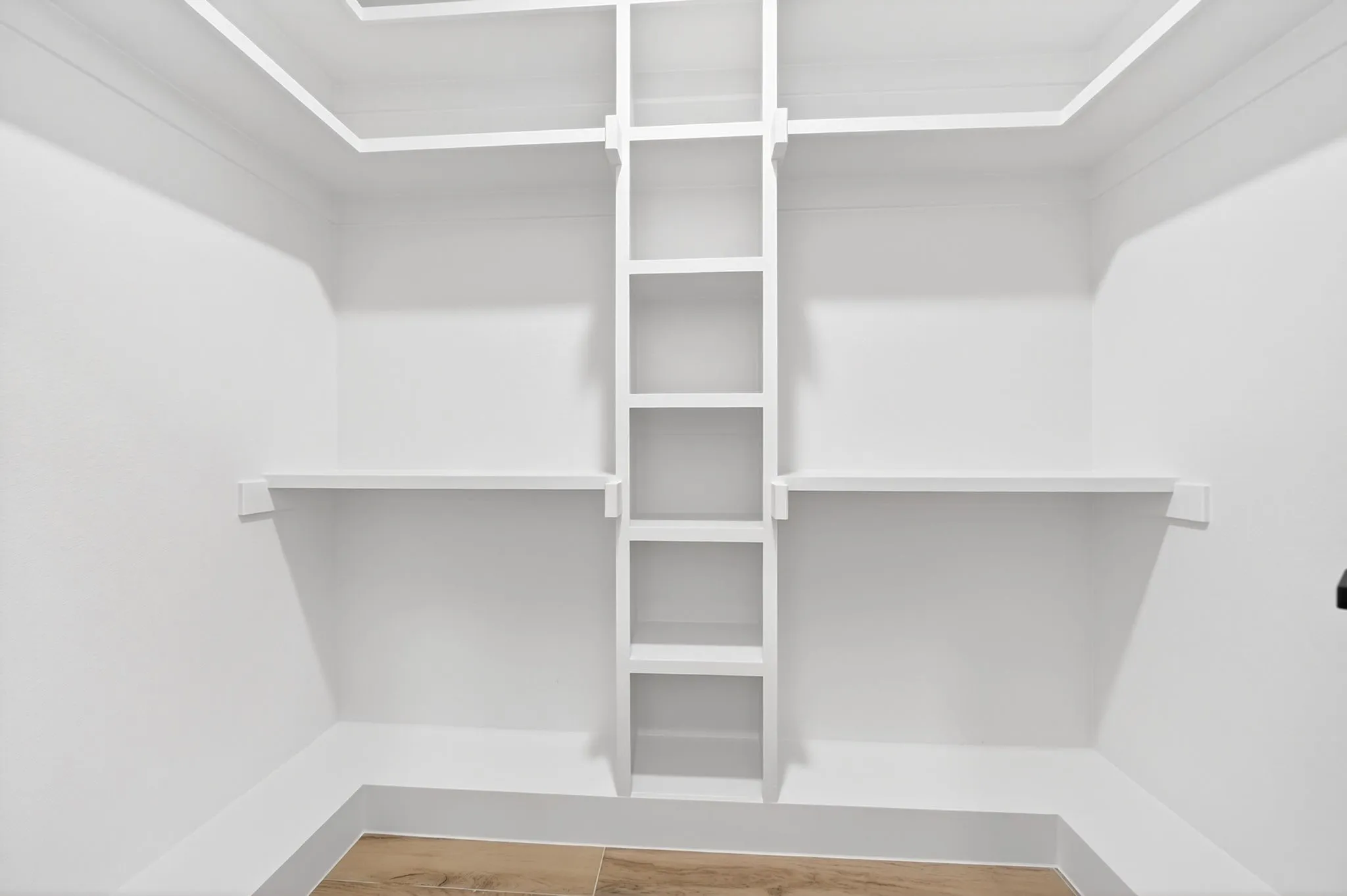 White built-in shelving, white walls, and wood-finish flooring