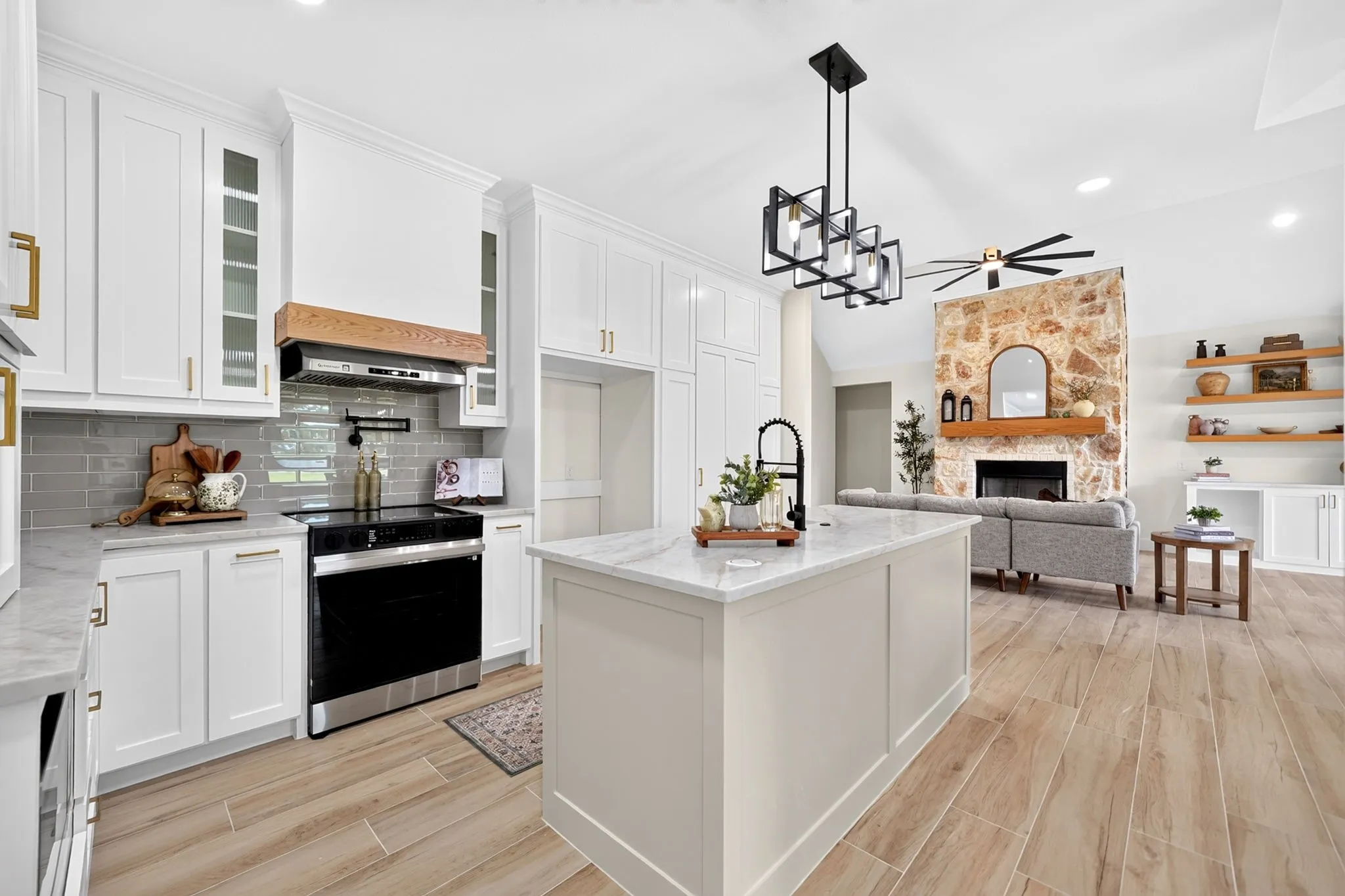 Kitchen featuring white cabinetry, a center island with countertop, an electric range, and wood-finish flooring