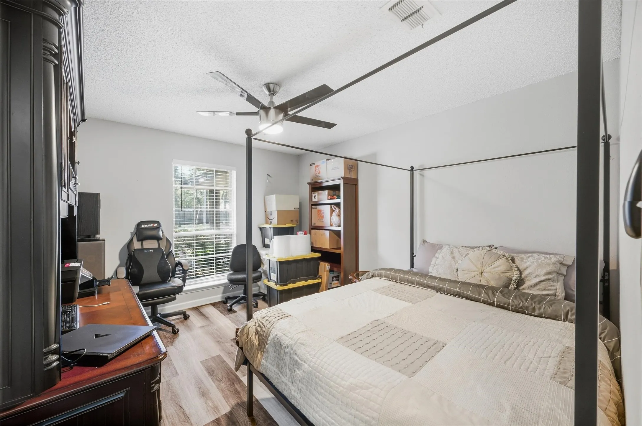 Light-toned walls with wood-finish flooring, featuring a ceiling fan with integrated lighting