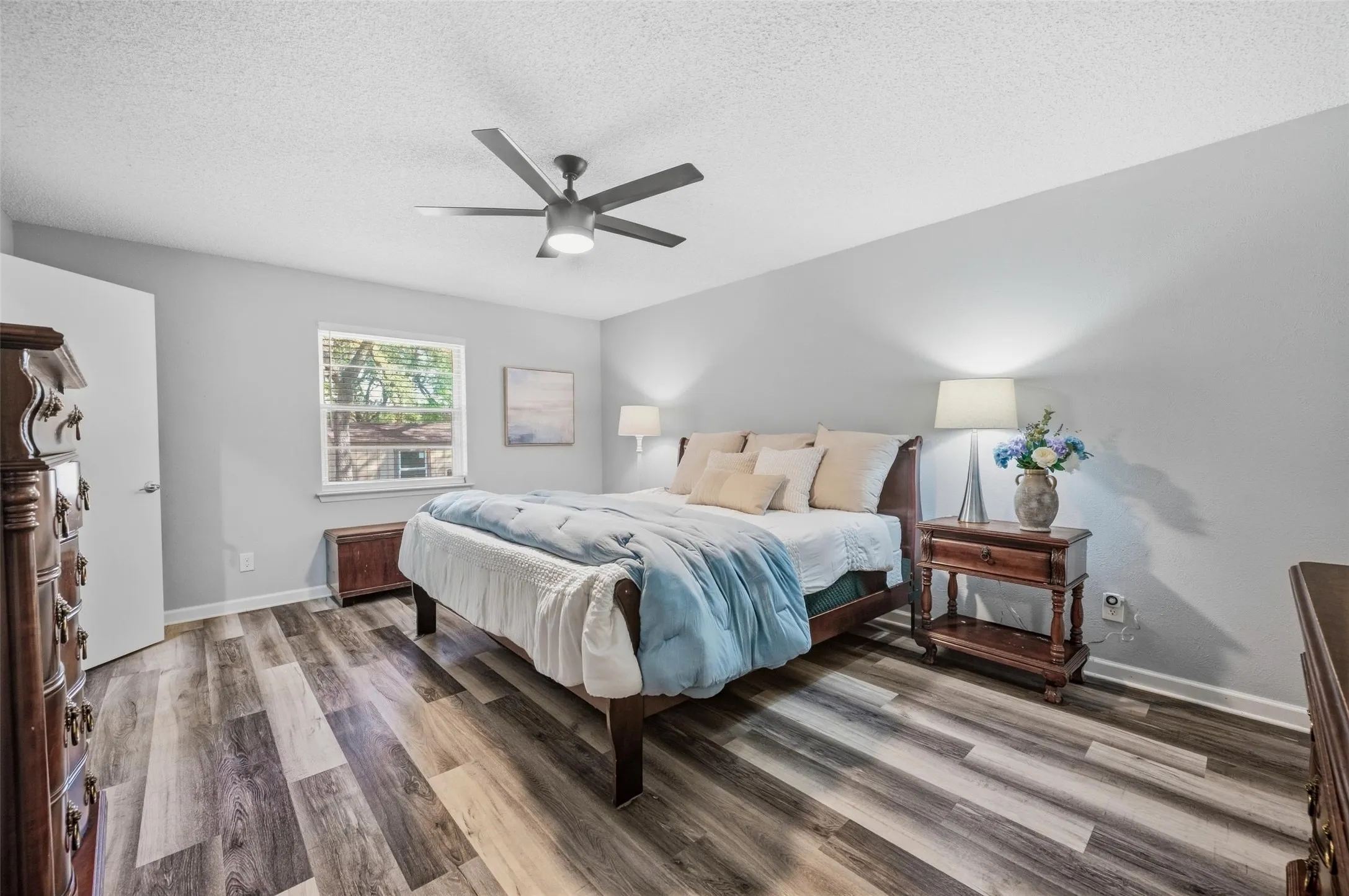 Wood-finish flooring, ceiling fan, window with natural light, and light-toned walls