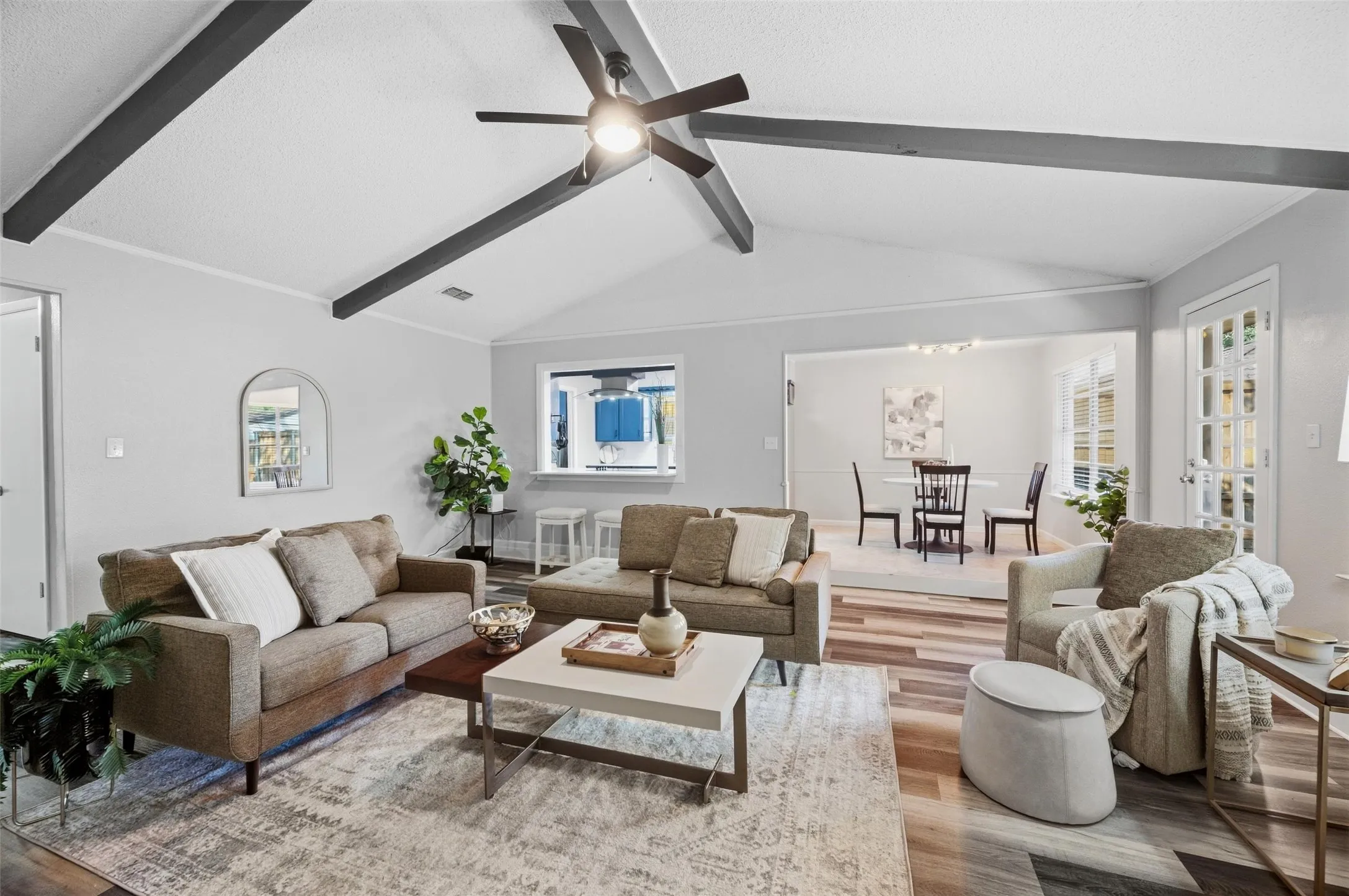 Vaulted ceiling with exposed beams, wood-finish flooring, recessed lighting, and a ceiling fan