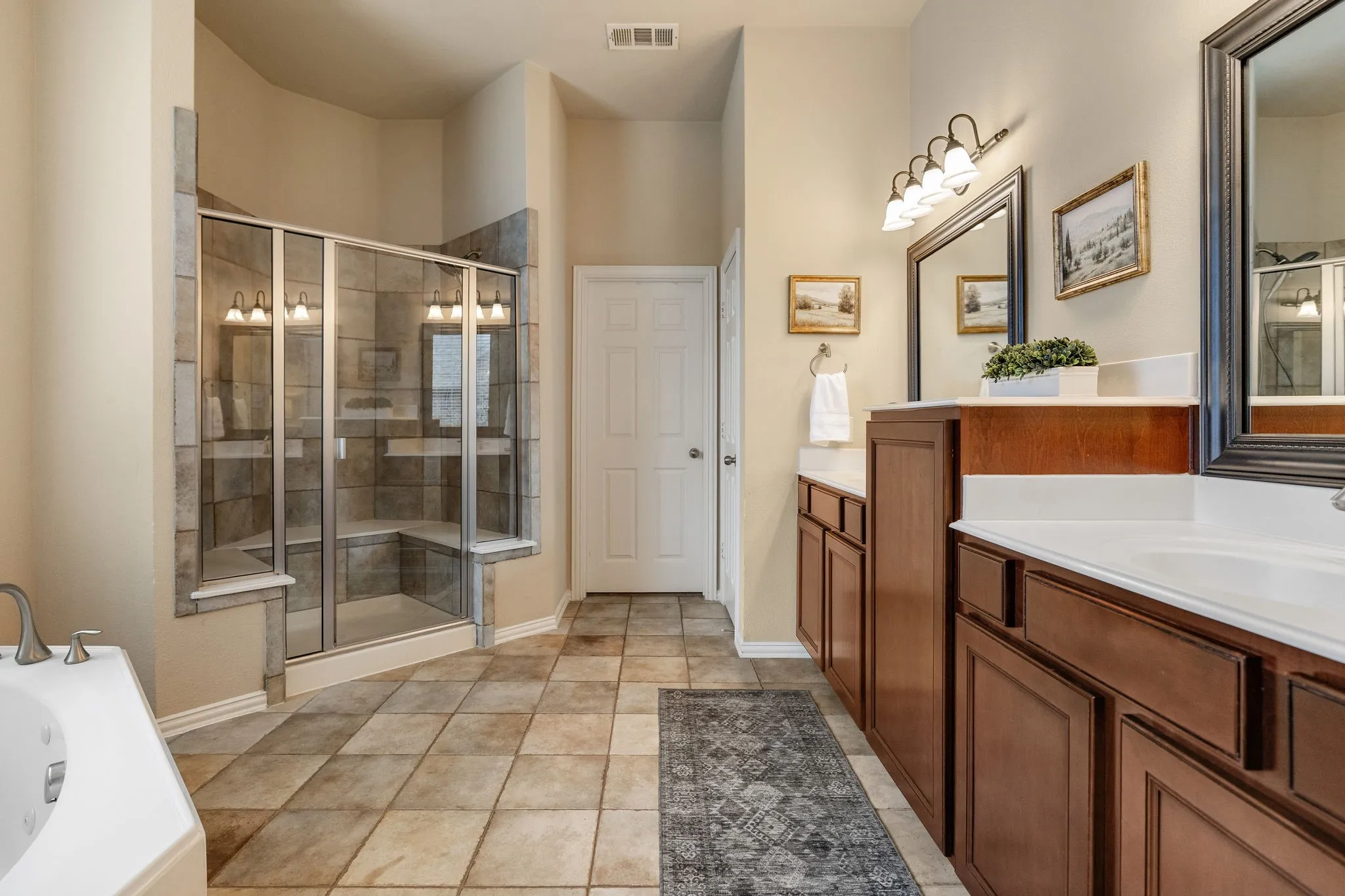 Very spacious and well kept primary bathroom.  Large walk-in shower with built-in seating.