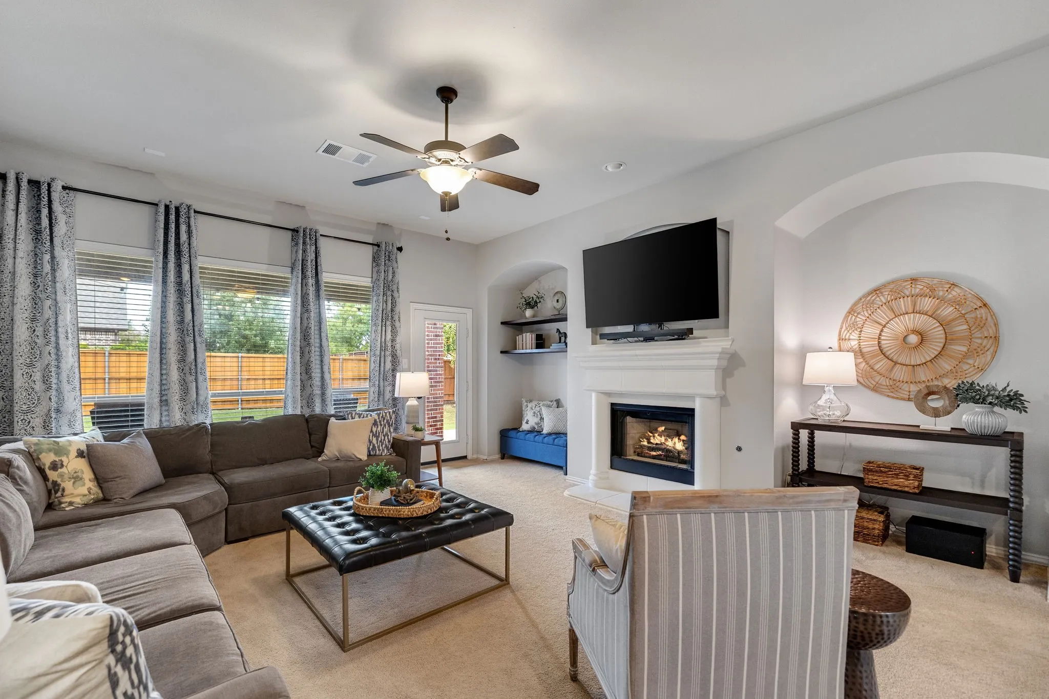 Lovely cast stone fireplace focal point with gas logs flanked by dual arched alcoves.