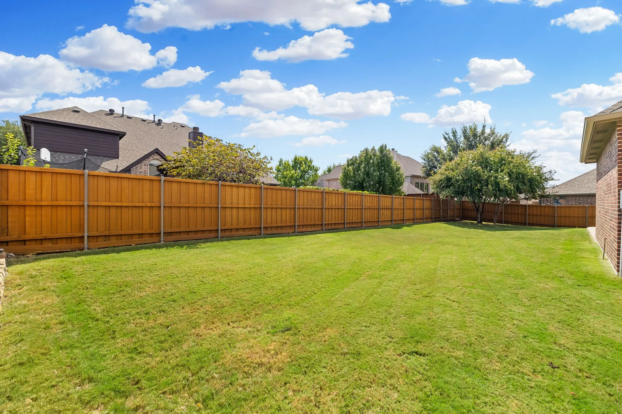 An expansive backyard featuring a well manicured lawn, 8 foot board on board cedar fence with steel posts that was re-stained in October 2025.