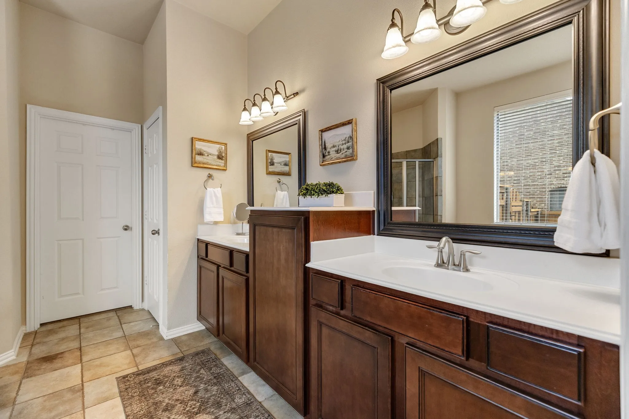 Solid maple dual vanities with white countertops, brushed nickel fixtures & large mirrors.