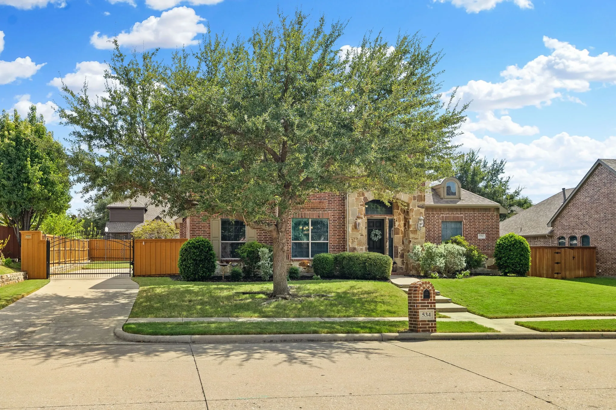Notice the lovely curb appeal, extensive stone facade & charming arched dormer.  And the electric wrought iron gate is a wonderful bonus for added security, storage, parking & play area.